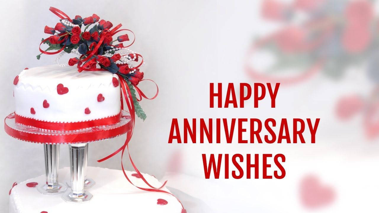 Happy Anniversary 桌布 壁紙 — 一個白色週年紀念蛋糕，裝飾著紅色愛心和花卉，旁邊是粗體紅色文字「HAPPY ANNIVERSARY WISHES」。