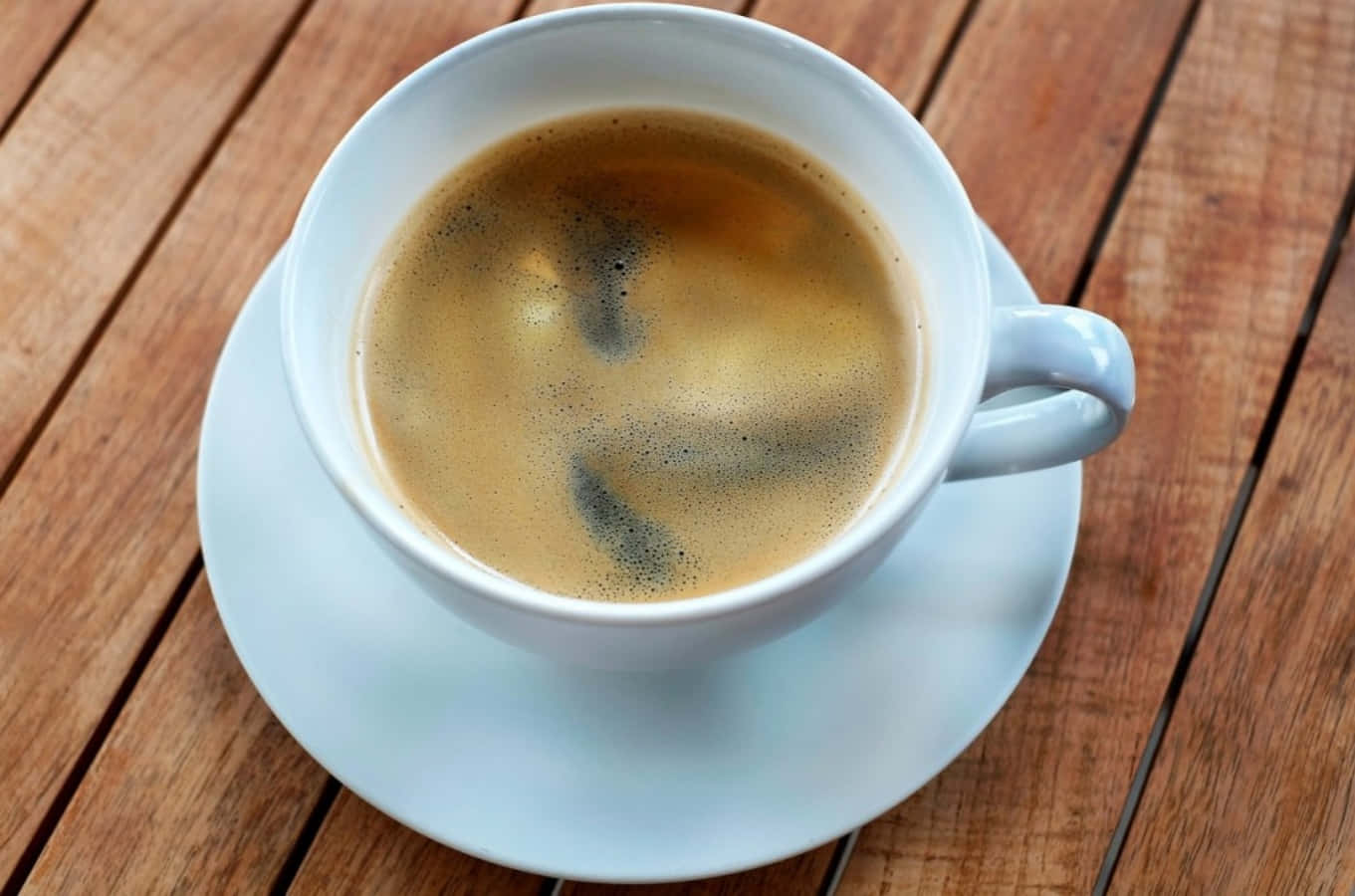 Morning Coffee 桌布 壁紙 — 一個白色陶瓷濃縮咖啡杯帶有咖啡油脂，放在相配的碟子上，置於溫暖的木桌上。