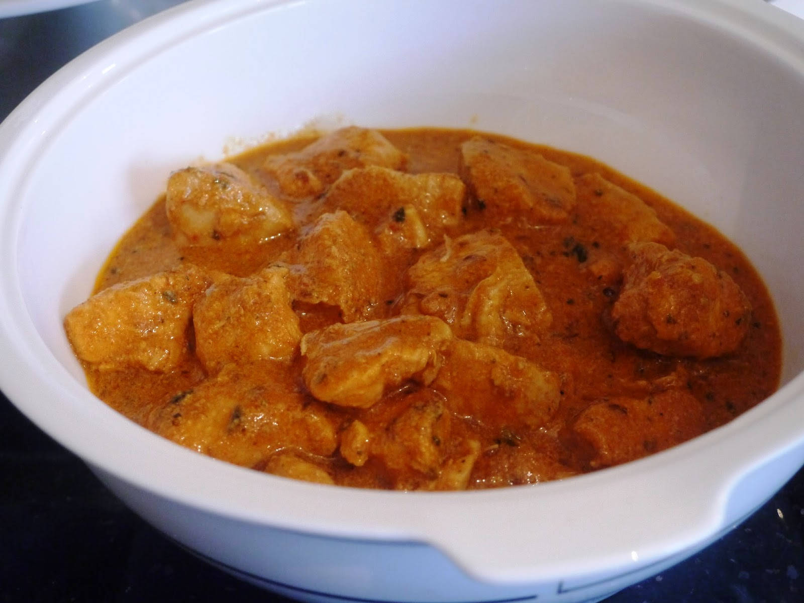 Chicken 桌布 壁紙 — 一個白色陶瓷碗，盛滿了用香草和香料慢煮的濃郁橙色雞肉咖哩。