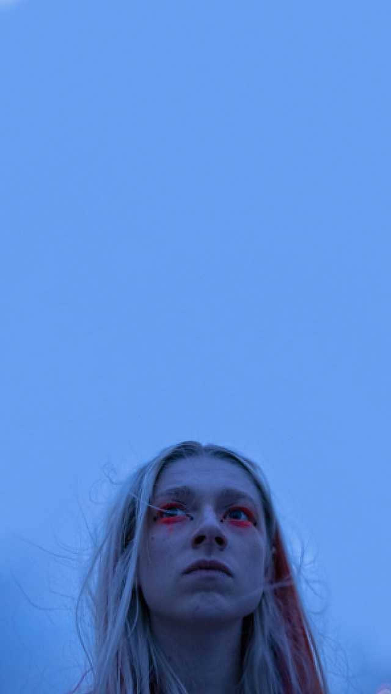 Hunter Schafer 桌布 壁紙 — 一個皮膚蒼白、眼睛紅色的人，仰望廣闊的藍天。