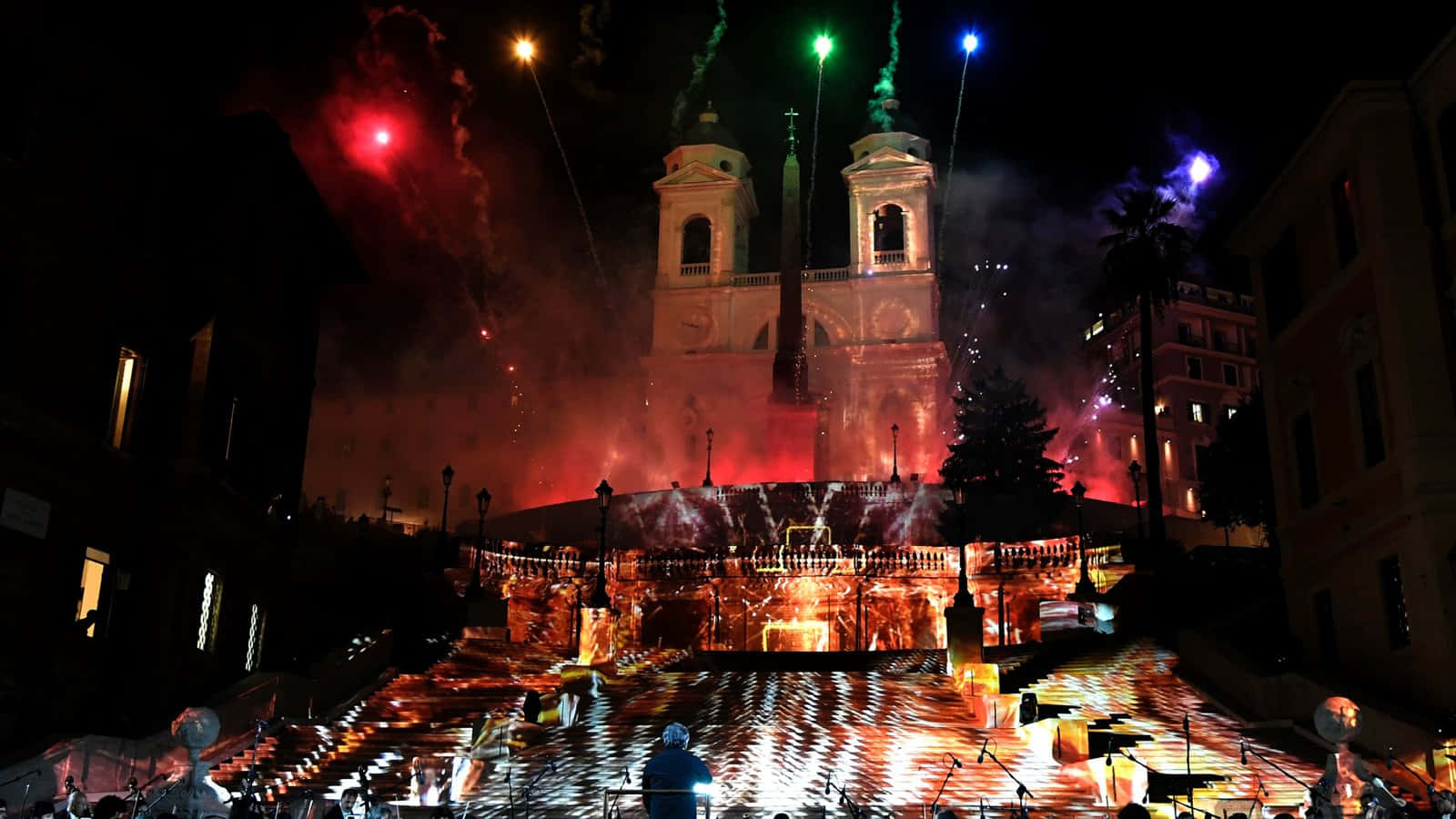 Fireworks 桌布 壁紙 — 一個盛大的夜間節日，煙火在歷史悠久的教堂和燈光噴泉上空綻放。