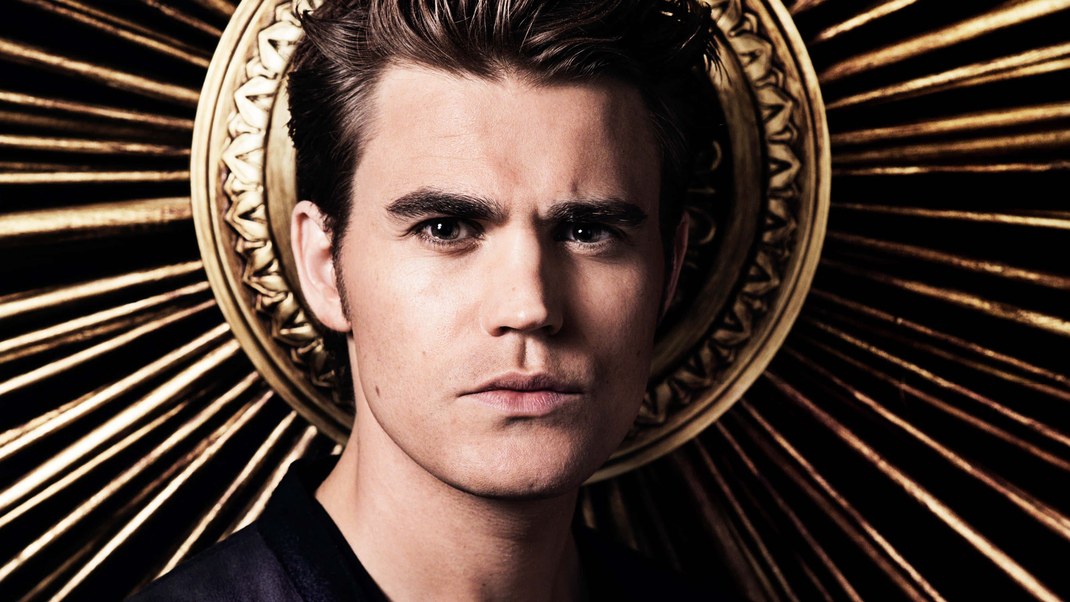 Vampire Diaries Desktop 桌布 壁紙 — 一個眼神強烈的男人，被金色華麗光環框住，背景是放射狀的金色光芒。