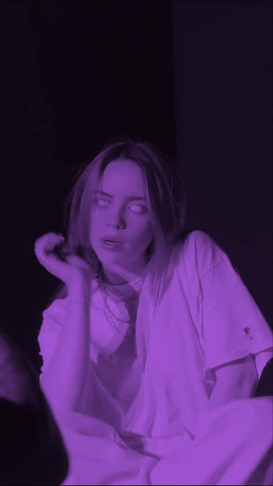鎖屏 桌布 壁紙 — 一個睜大眼睛、表情驚訝的人坐在昏暗的紫色房間裡，手靠近臉部。