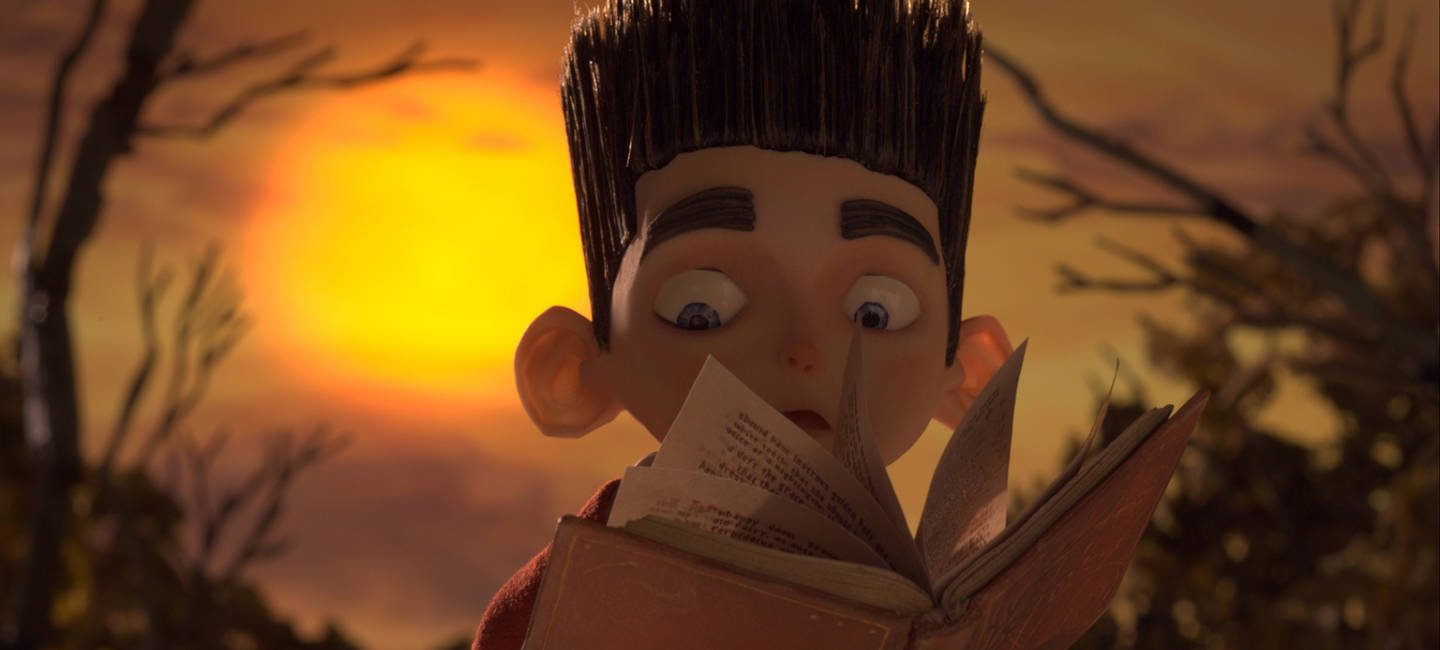 Animated 桌布 壁紙 — 一個睜大眼睛的動畫男孩，頭髮尖尖，在溫暖的日落背景下，光禿禿的樹木旁看書。