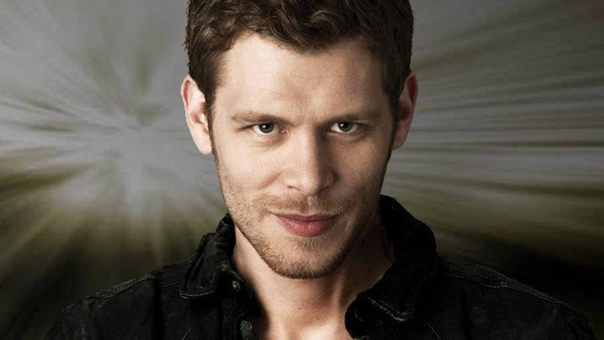 Vampire Diaries 桌布 壁紙 — 一個短棕髮、留著些許鬍鬚的男人，在模糊的放射狀背景下專注地凝視著相機。