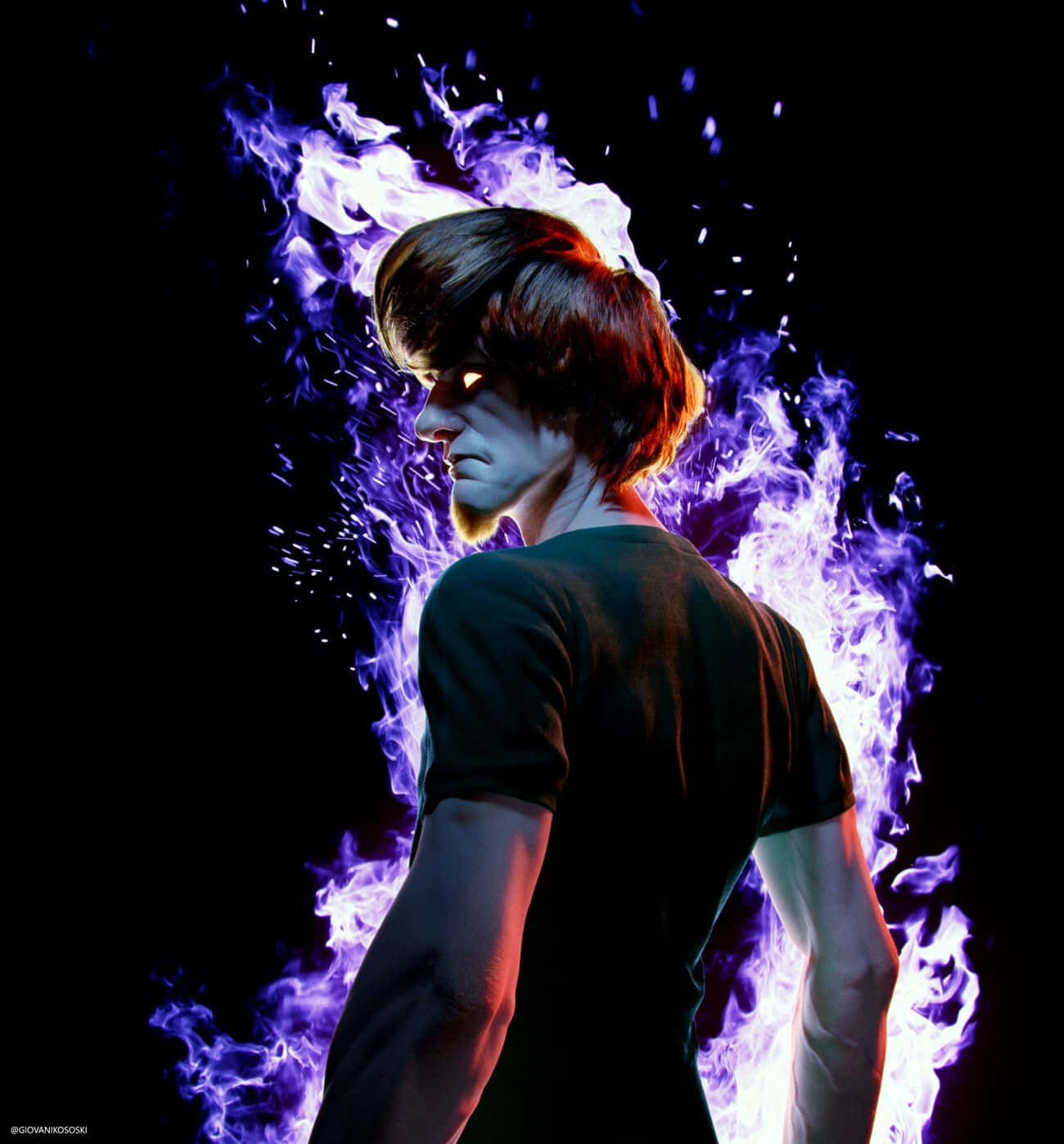 Shaggy Rogers 桌布 壁紙 — 一個短棕髮的男人側面站立，被鮮豔的紫色和白色火焰包圍，背景為黑色。