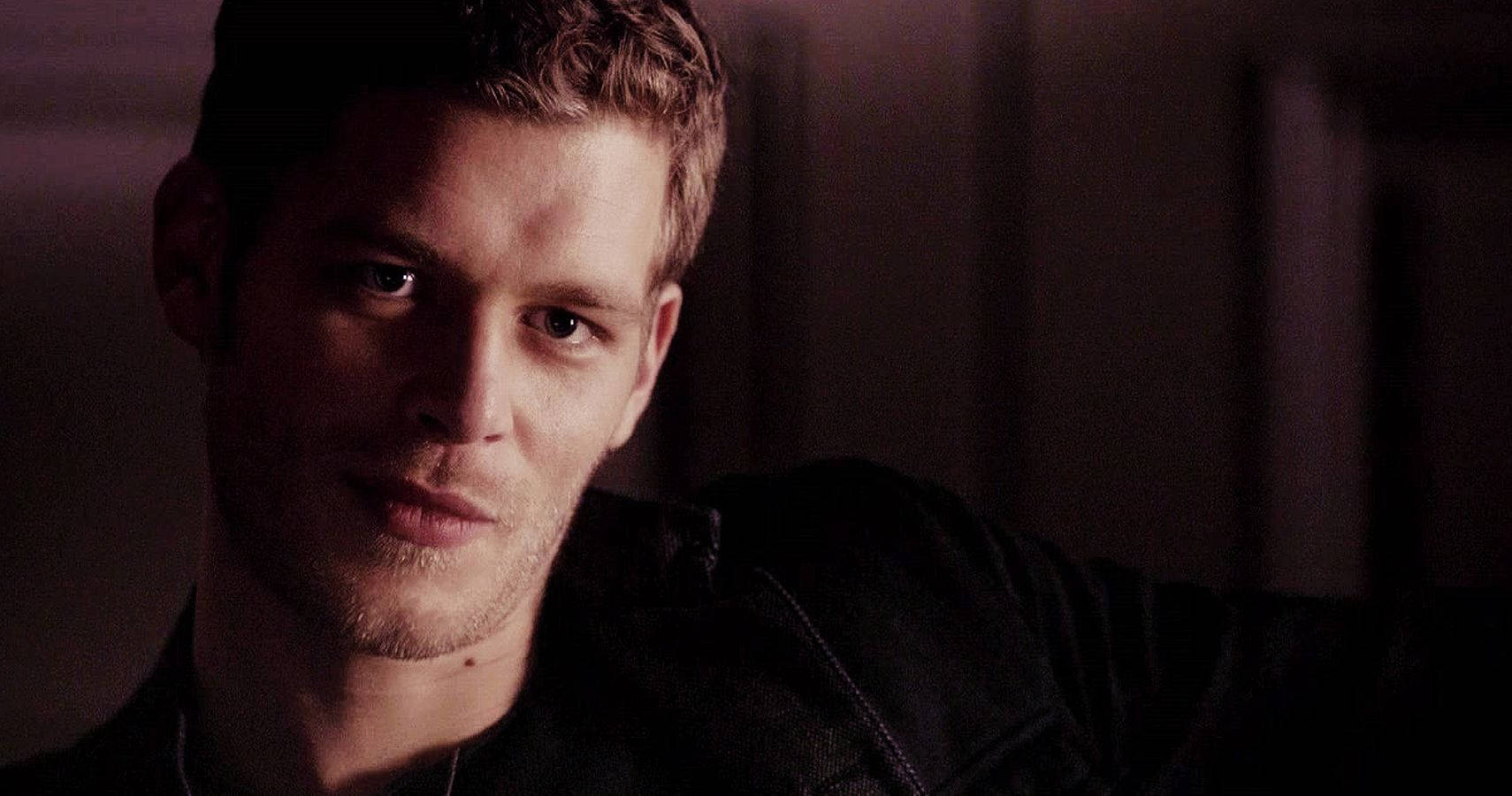 Vampire Diaries 桌布 壁紙 — 一個短金髮、鬍渣的男人在光線昏暗、色調溫暖的房間裡專注地凝視。