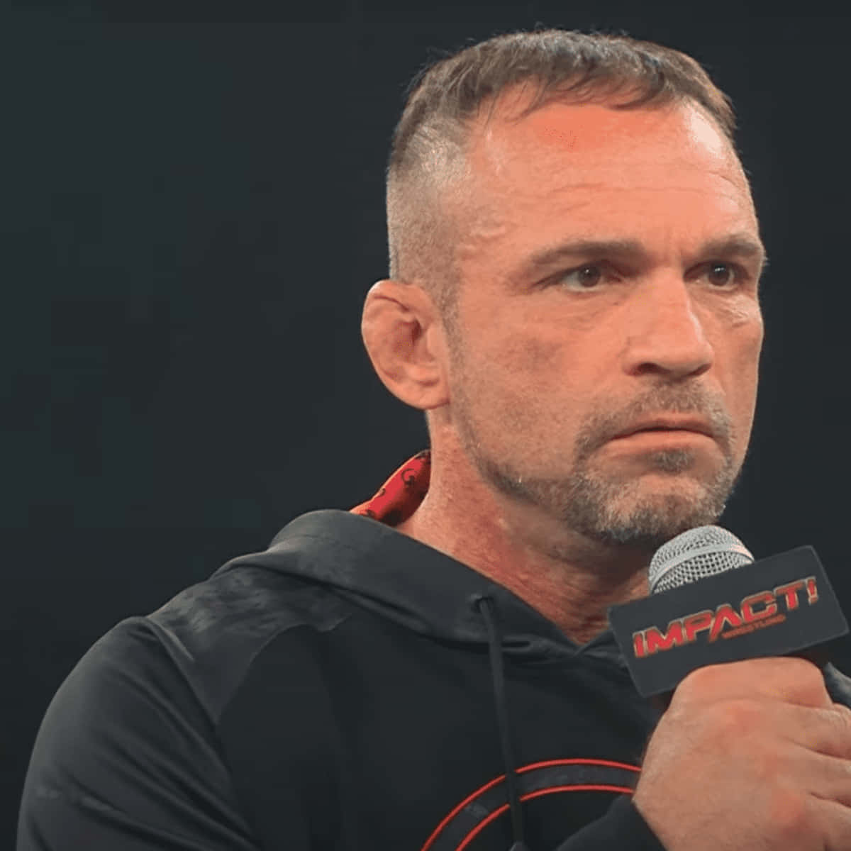Charlie Haas 桌布 壁紙 — 一個短髮、有鬍渣的男人在黑色背景前對著一個印有「IMPACT!」的麥克風說話。