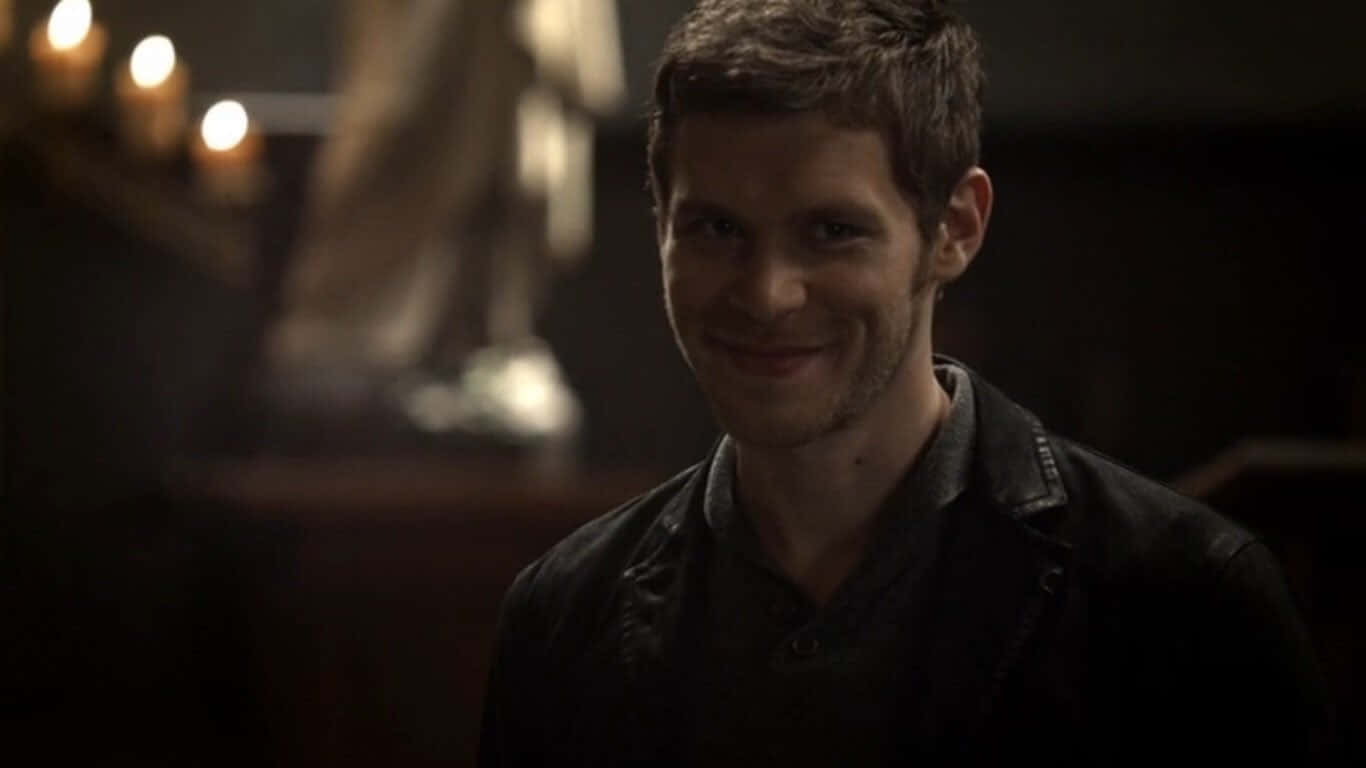 Vampire Diaries 桌布 壁紙 — 一個短黑髮的男人在燭光照亮的昏暗房間裡溫柔地微笑。