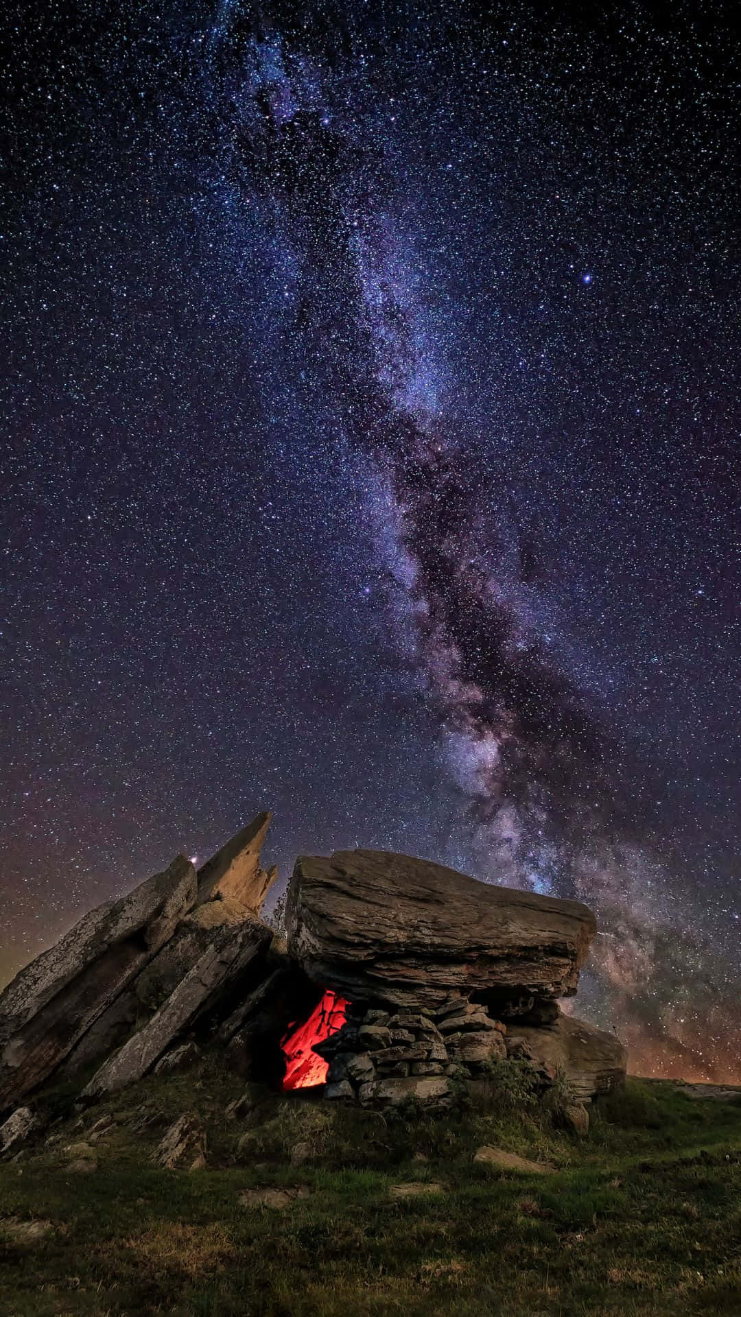 星空動畫 桌布 壁紙 — 一個石頭庇護所在壯麗的星空下發出紅光，星空充滿了銀河。
