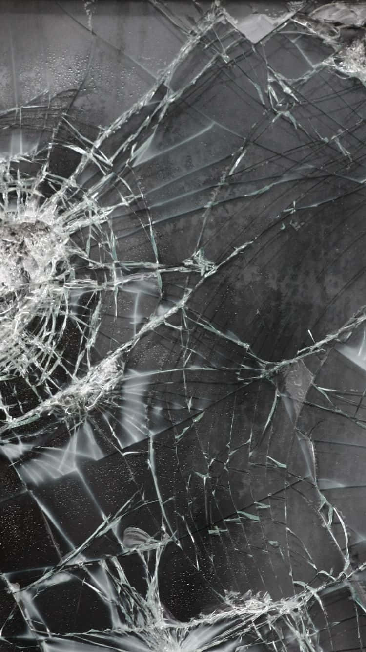 iPhone 桌布 壁紙 — 一個破碎的玻璃表面，帶有複雜的裂紋和反光碎片，背景為深色。