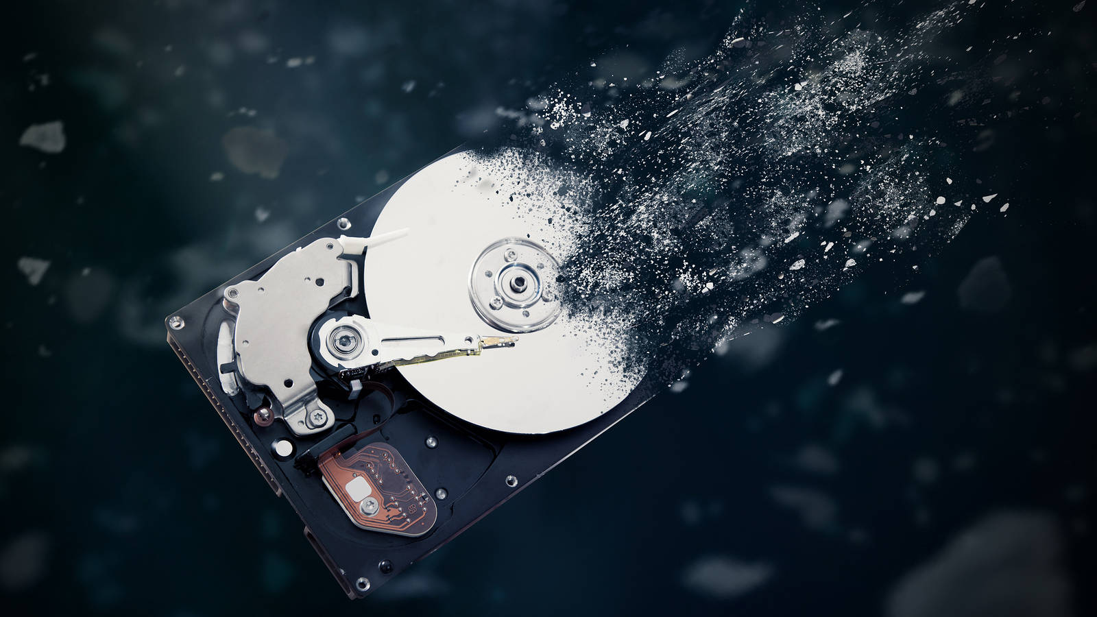 Hard Drive 桌布 壁紙 — 一個破碎的硬碟，金屬碎片在黑暗背景上爆炸。
