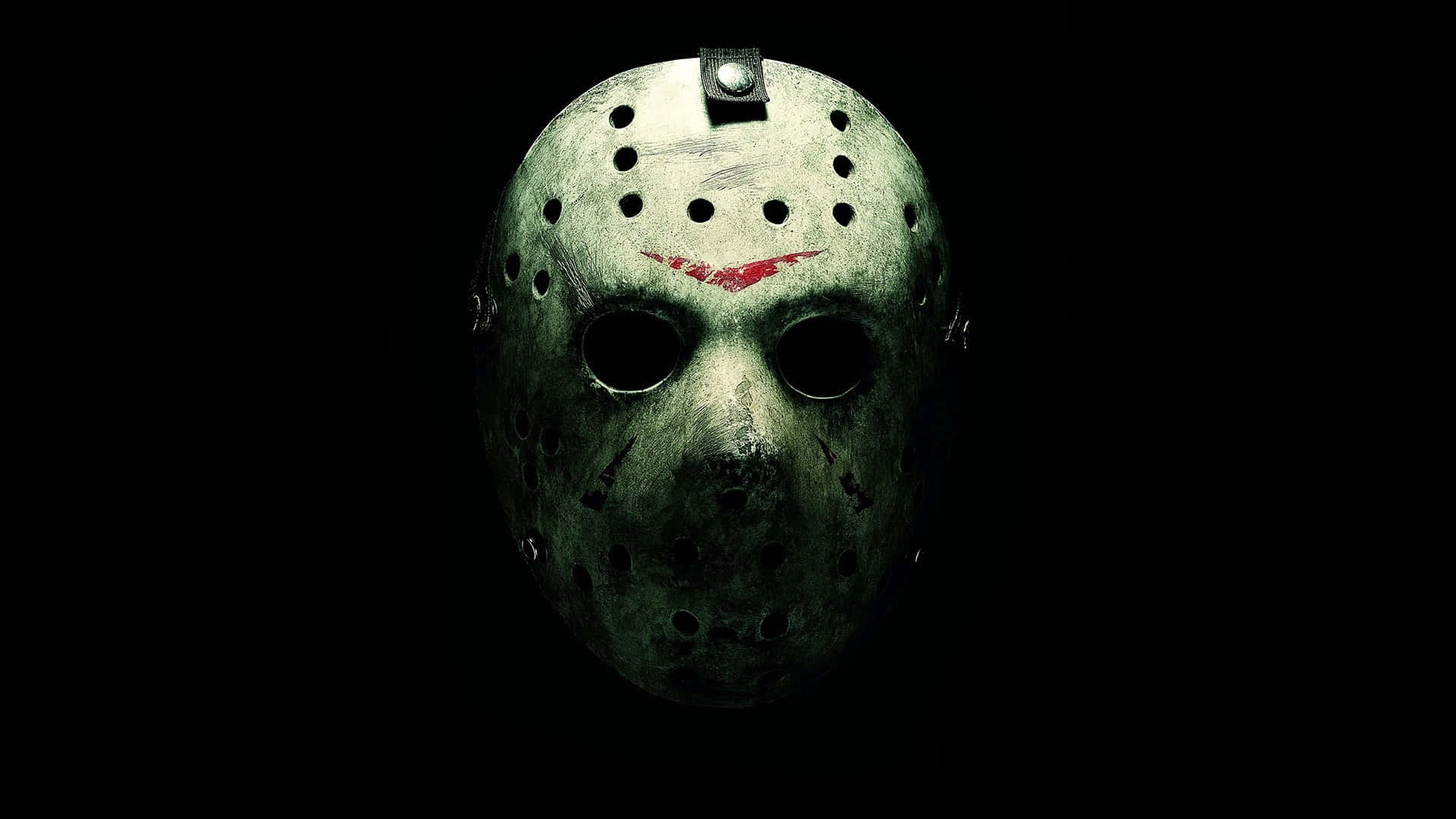 Halloween Profile 桌布 壁紙 — 一個破舊的曲棍球面具，帶有血跡和紅色劃痕，在漆黑的背景上發光。
