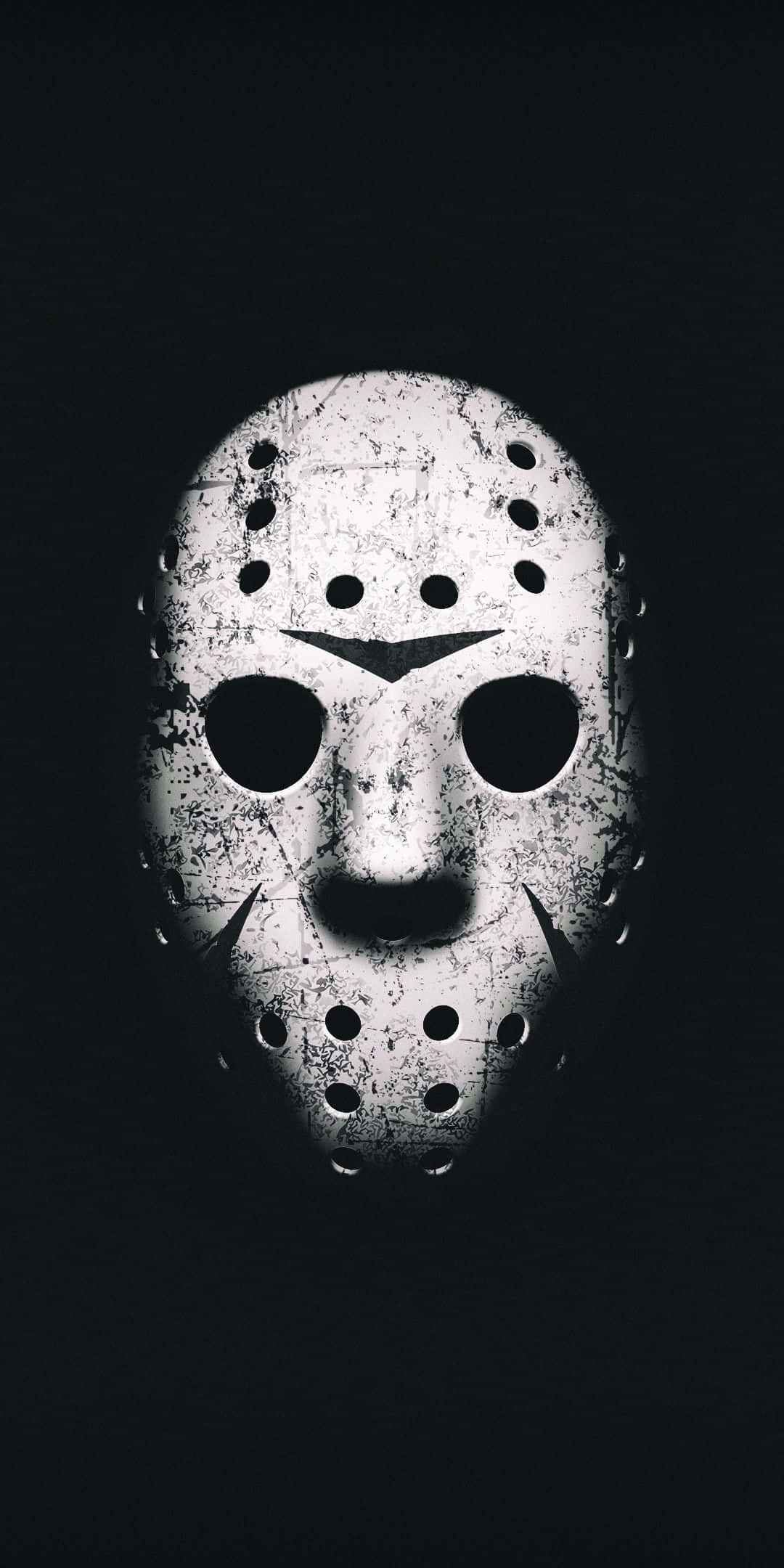 Horror Masks 桌布 壁紙 — 一個破舊的白色曲棍球面具，帶有孔洞，在漆黑的背景上發光。