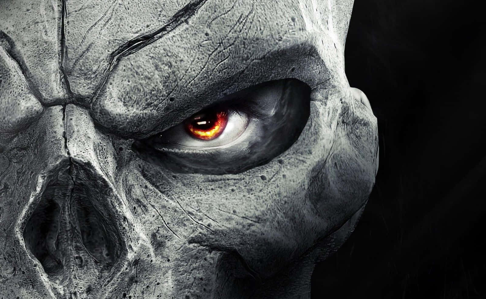 Cool Scary 桌布 壁紙 — 一個破裂的灰色頭骨的特寫，單一發光的火橙色眼睛在黑色背景下強烈凝視。