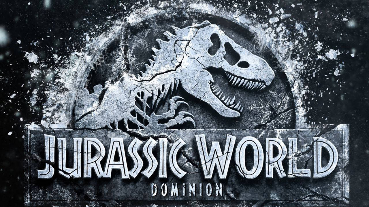 World 桌布 壁紙 — 一個破裂的石頭標誌，展示咆哮的恐龍頭骨，並帶有「Jurassic World Dominion」字樣，以粗糙的金屬字體呈現。