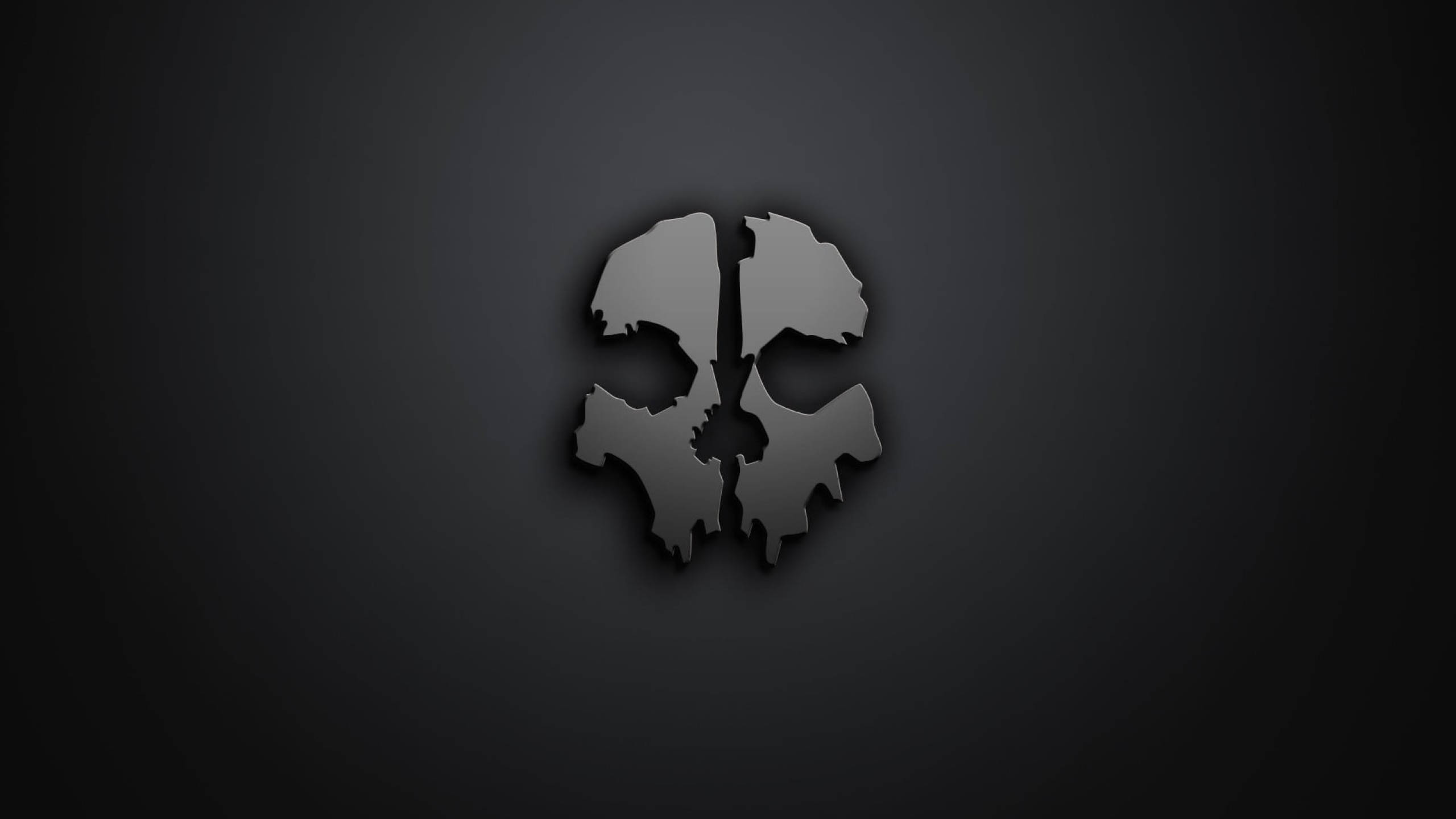 Gaming Logos 桌布 壁紙 — 一個碎裂的金屬骷髏標誌在深色漸變背景上微微發光。
