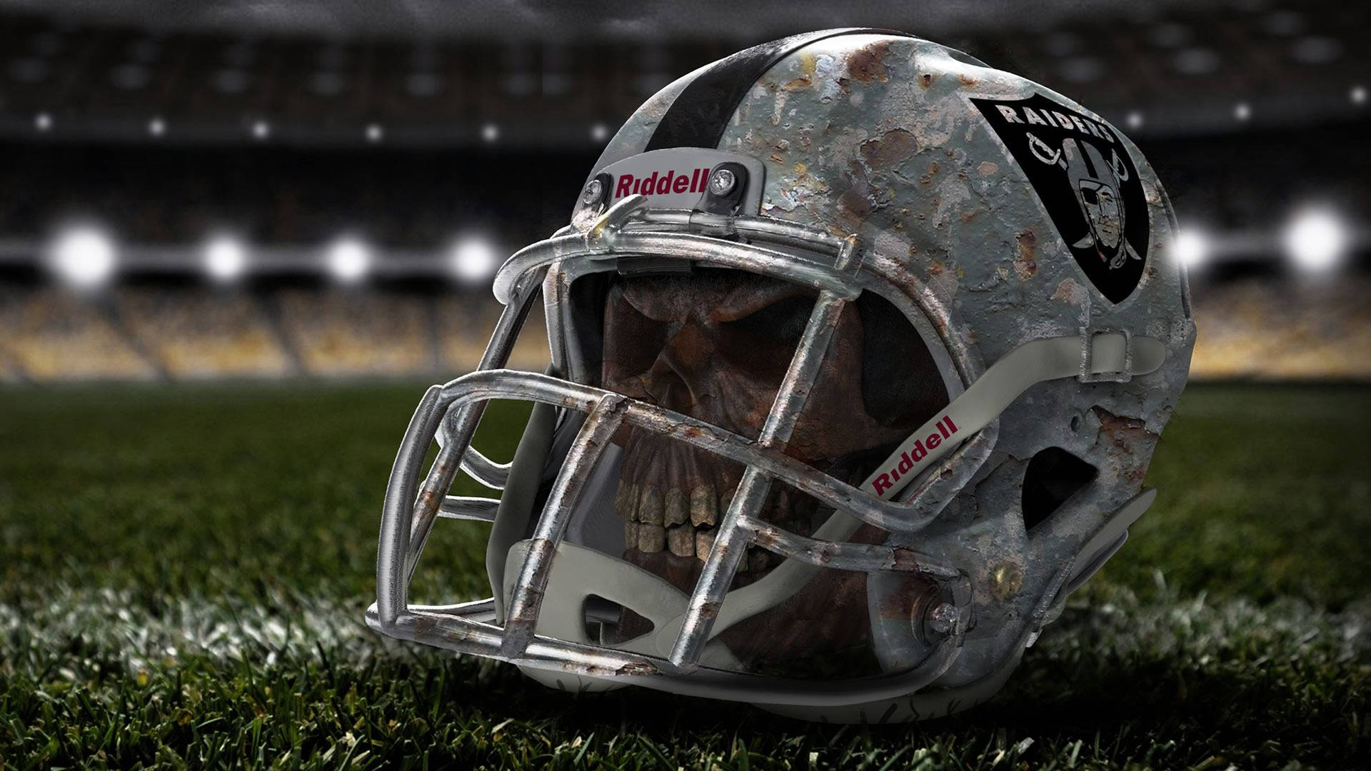 Raiders 美式足球頭盔，裡面有頭骨，在草地上。 — 突襲者 GIF 壁紙