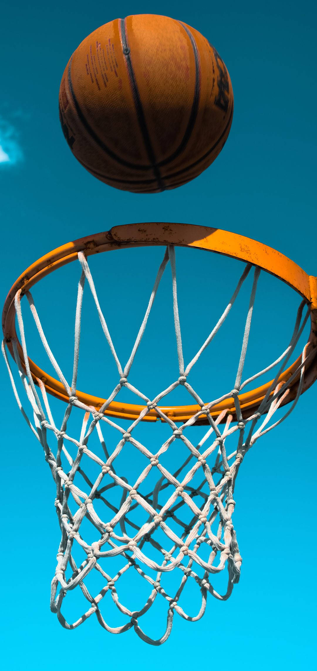 ball 桌布 壁紙 — 一個磨損的籃球懸掛在一個風化的籃框上方，背景是鮮豔的藍天。
