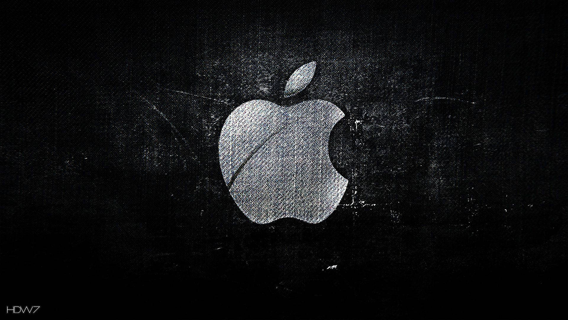 Black Desktop 桌布 壁紙 — 一個磨損的銀色Apple標誌在帶有細微刮痕和顆粒的紋理黑色背景上發光。