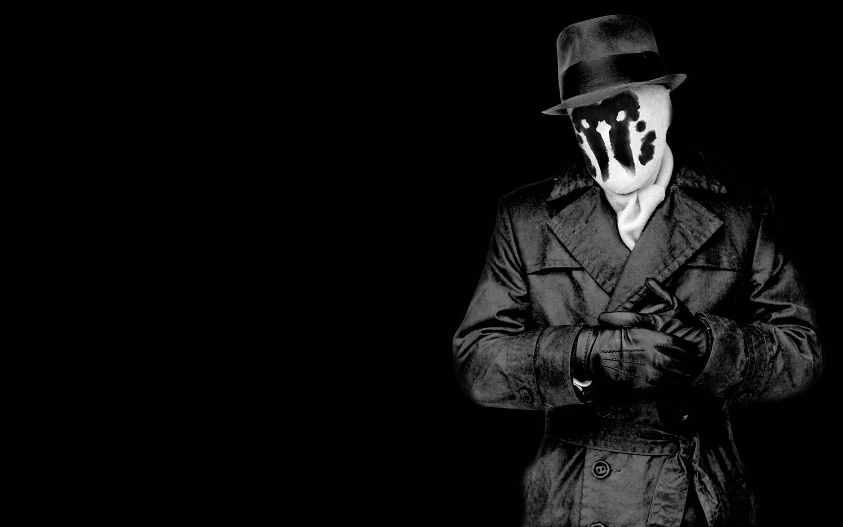 Watchmen 桌布 壁紙 — 一個神秘人物戴著紳士帽和風衣，站在黑色背景前，戴著帶有黑色飛濺的白色面具。