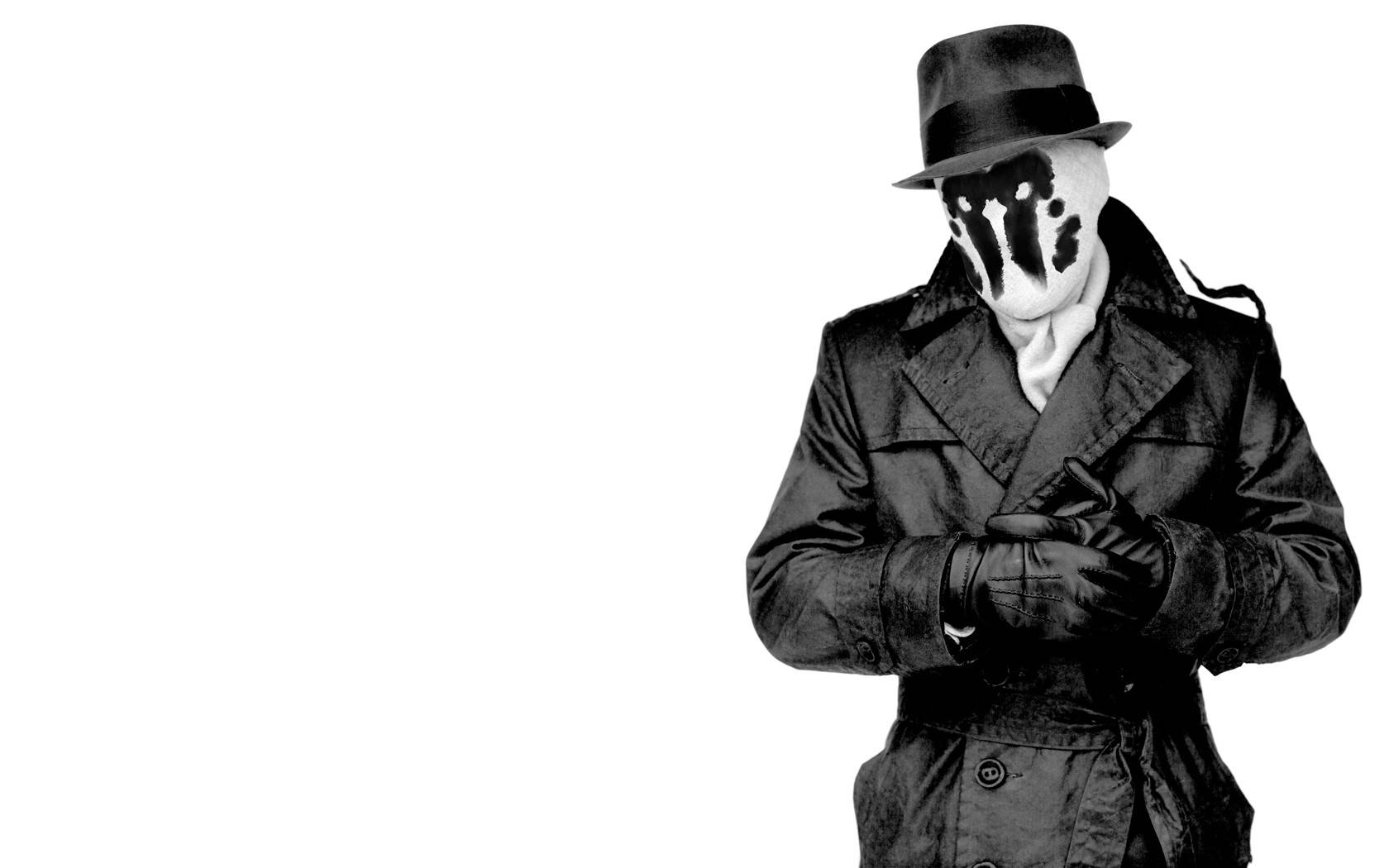 Watchmen 桌布 壁紙 — 一個神秘人物身穿黑色風衣和軟呢帽，站在純白色背景前，戴著獨特的黑白圖案面具。