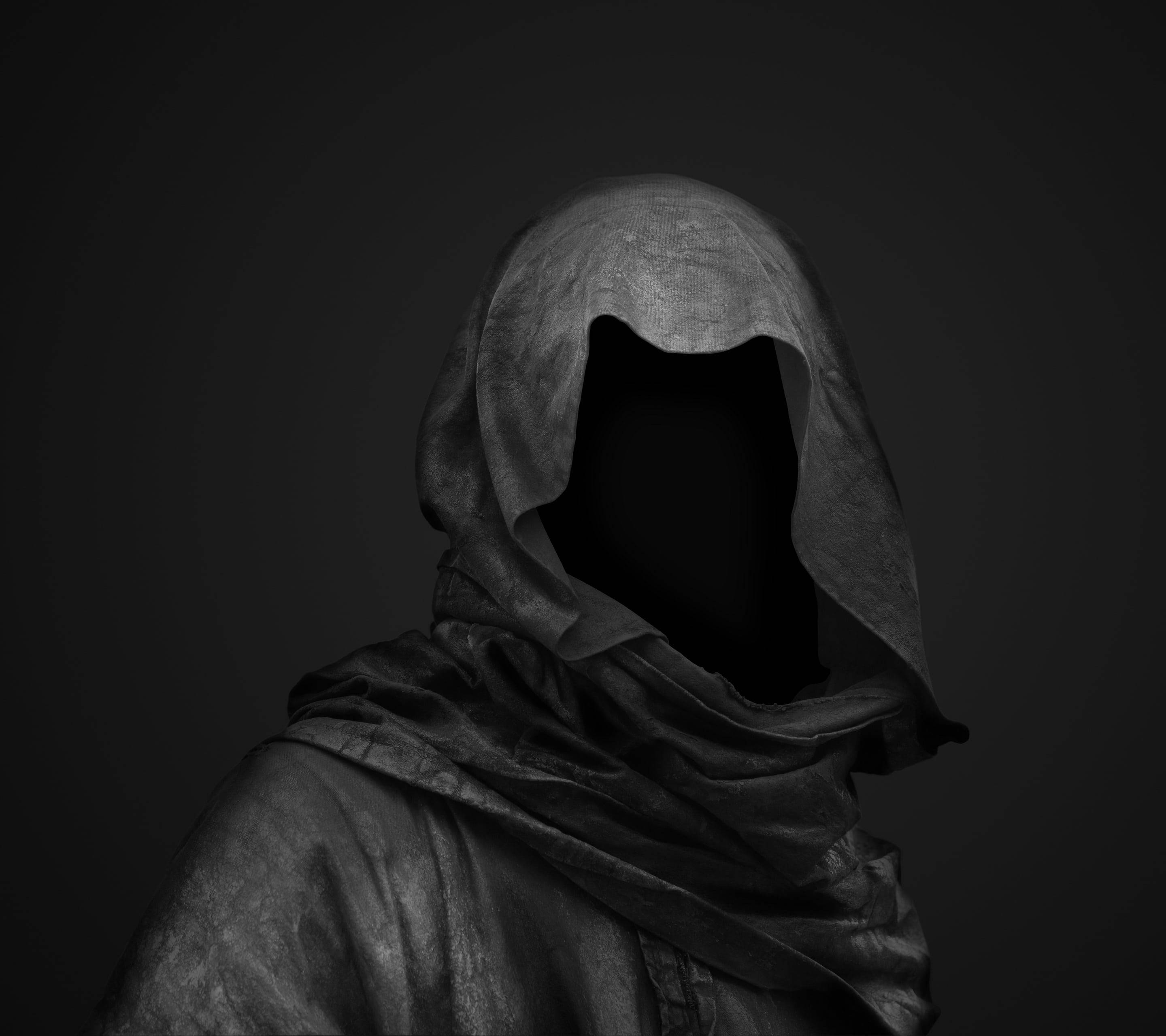 Most Scary 桌布 壁紙 — 一個神秘戴兜帽的人物，臉部是一個沒有特徵的黑色虛空，站在深色漸變背景前。