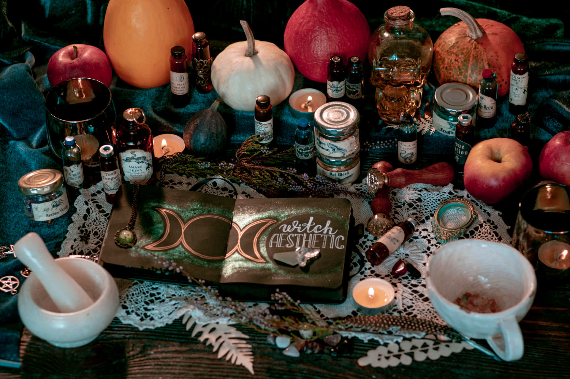 Witching Hour 桌布 壁紙 — 一個神秘的巫師美學祭壇，在昏暗燭光下裝飾著南瓜、蘋果、蠟燭和月相符號。