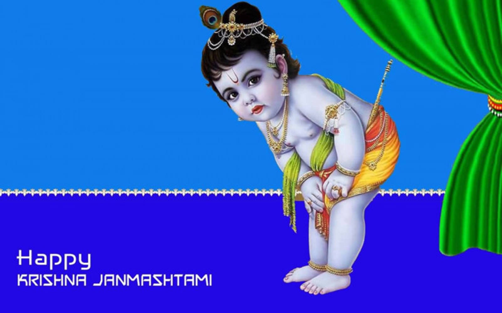 Indian 桌布 壁紙 — 一個神聖的嬰兒克里希納，身穿華麗的金色服飾和孔雀羽毛冠冕，站在綠色窗簾旁邊，背景是鮮豔的藍色。