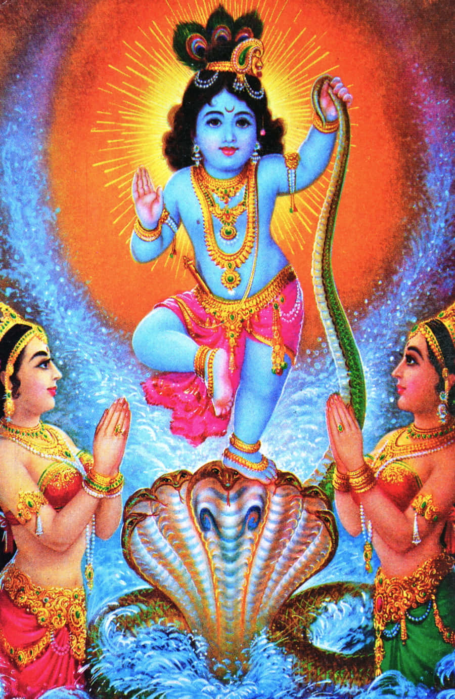Hindu God 桌布 壁紙 — 一個神聖的藍色小孩戴著孔雀冠冕，站在一條盤繞的蛇上，兩旁有兩位祈禱的女性，在熾熱的橙色和藍色背景下散發著金色的光芒。