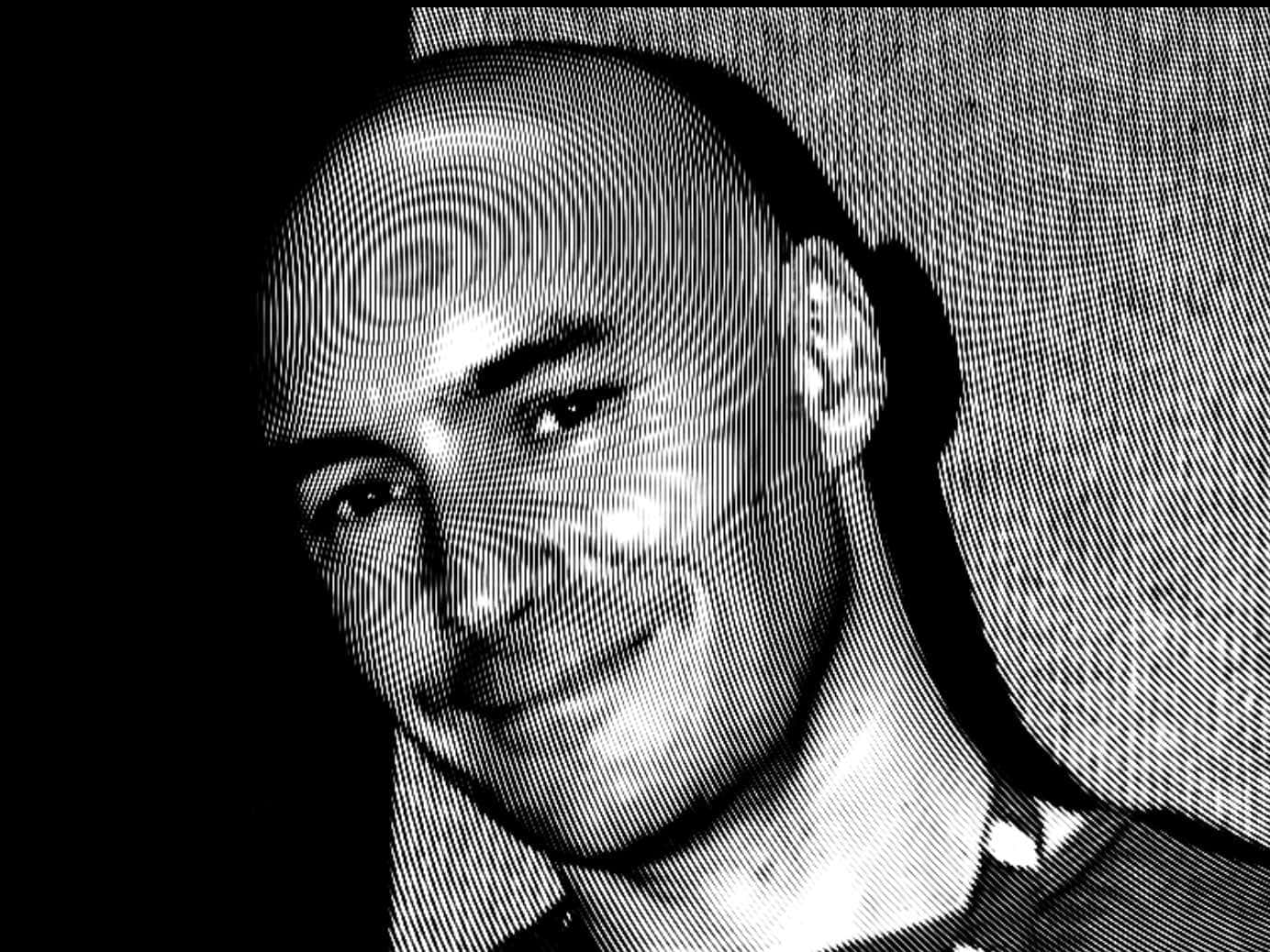 Grant Morrison 桌布 壁紙 — 一個禿頭男人微笑的黑白半色調肖像，帶有紋理背景。