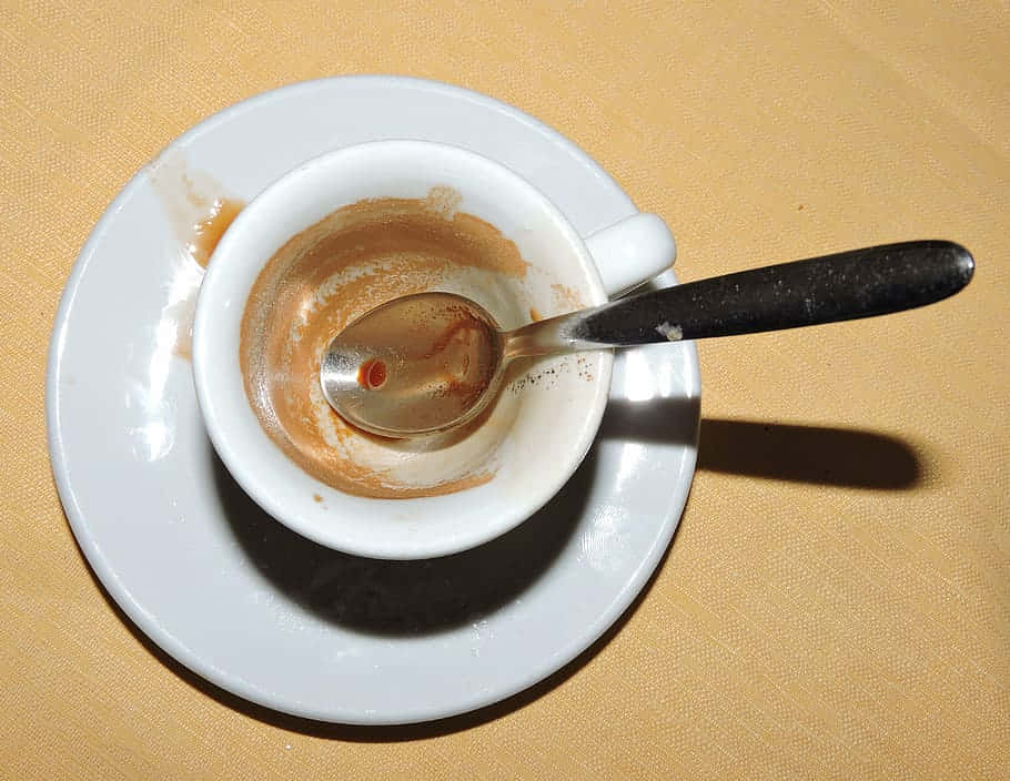 kitchen 桌布 壁紙 — 一個空的白色濃縮咖啡杯配湯匙，放在有紋理的米色桌布上的碟子上。