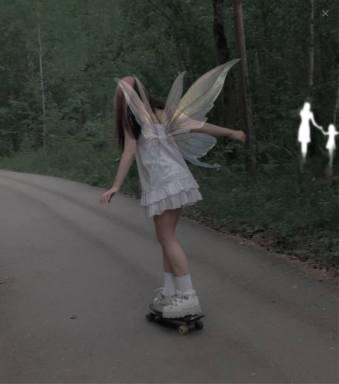 Fairy Grunge 桌布 壁紙 — 一個穿著仙女服裝、擁有半透明翅膀的人踩著滑板沿著森林道路滑行，背景中有幽靈般的身影。