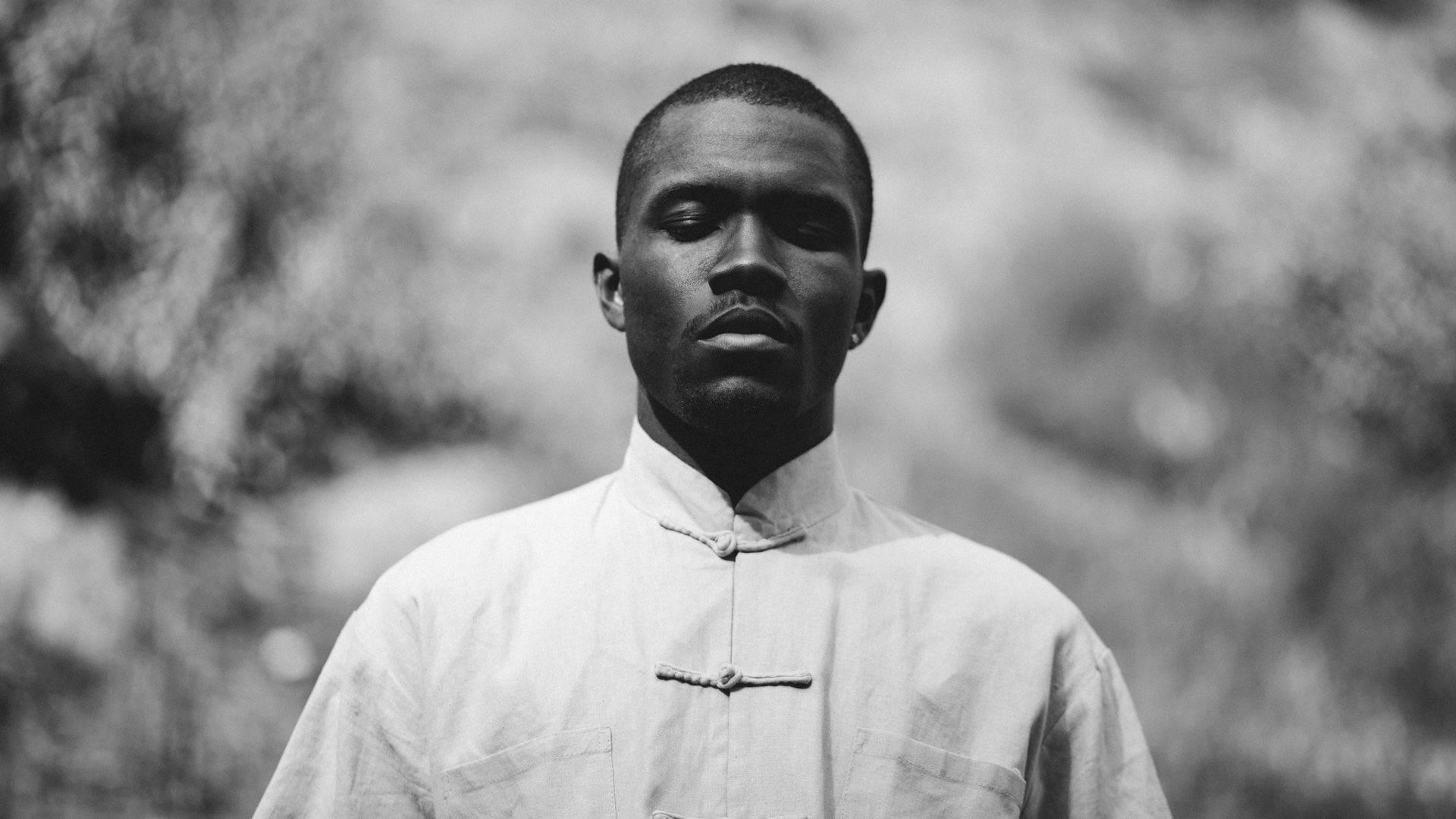 Frank Ocean 桌布 壁紙 — 一個穿著傳統有領襯衫的男人黑白肖像，站在模糊的自然背景前。