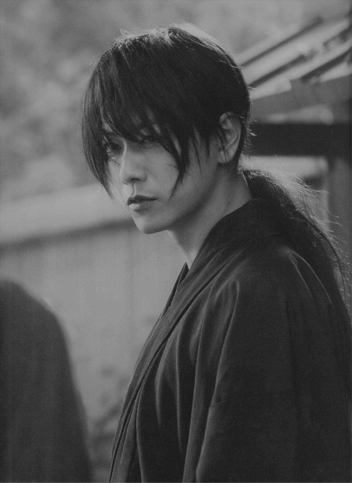 Kenshin 桌布 壁紙 — 一個穿著傳統長袍、留著深色長髮的人的黑白肖像，表情嚴肅地望向鏡頭外。