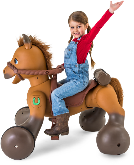 Horse Riding 桌布 壁紙 — 一個穿著吊帶褲的開朗女孩，在黑色背景前騎著一匹棕色的有輪玩具馬，一隻手臂高高舉起。