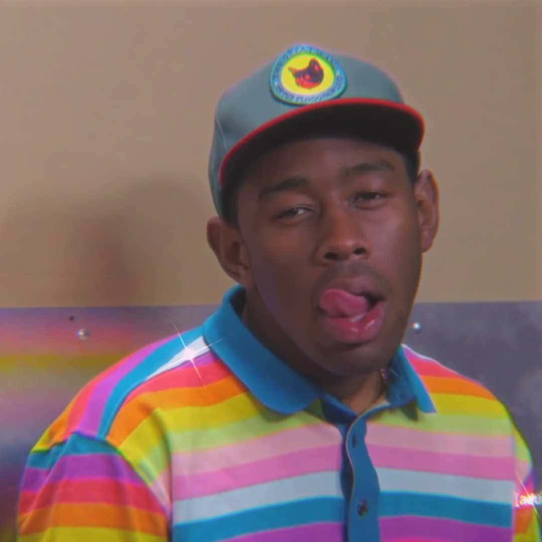 Rappers 桌布 壁紙 — 一個穿著彩虹條紋Polo衫和帽子的男人，伸出舌頭，表情頑皮。