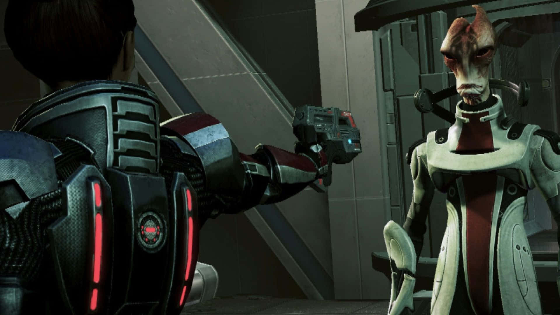 Mordin Solus 桌布 壁紙 — 一個穿著未來裝甲的人類在金屬走廊中用武器指向一個具威脅性的外星人。