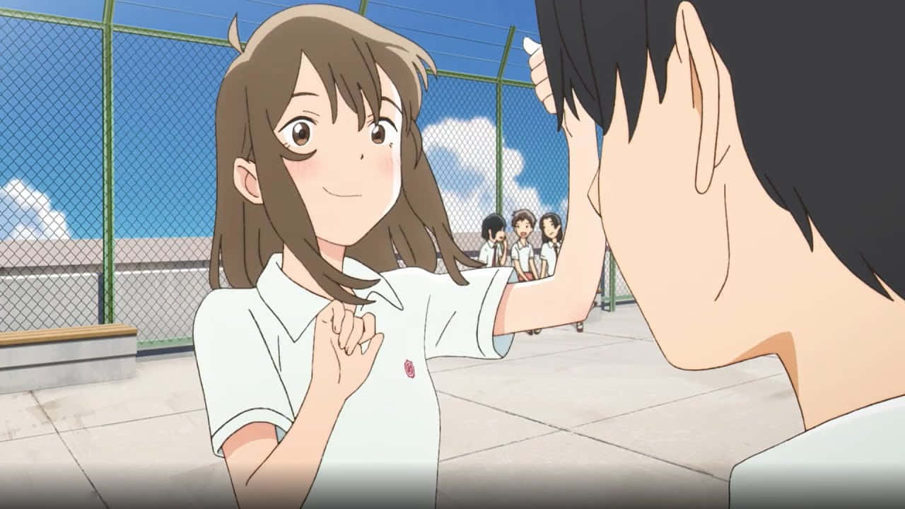 A Whisker Away 桌布 壁紙 — 一個穿著校服、開朗的動畫女孩在陽光明媚的校園裡微笑著為一個男孩整理頭髮，背景中有同學們。