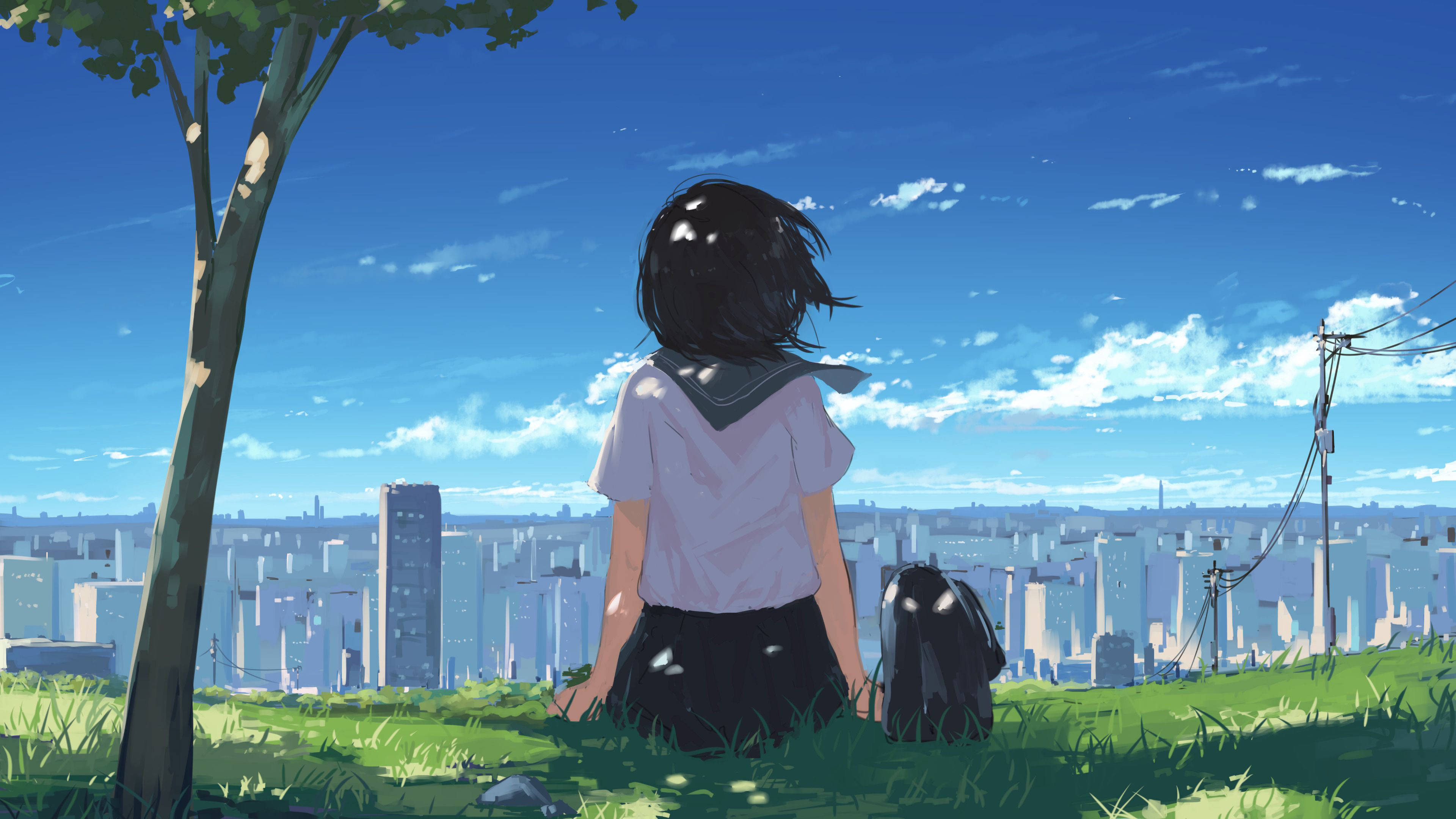 桌布 壁紙 — 一個穿著校服的女孩坐在樹下的草地上，俯瞰著明亮藍天下廣闊的城市景觀。