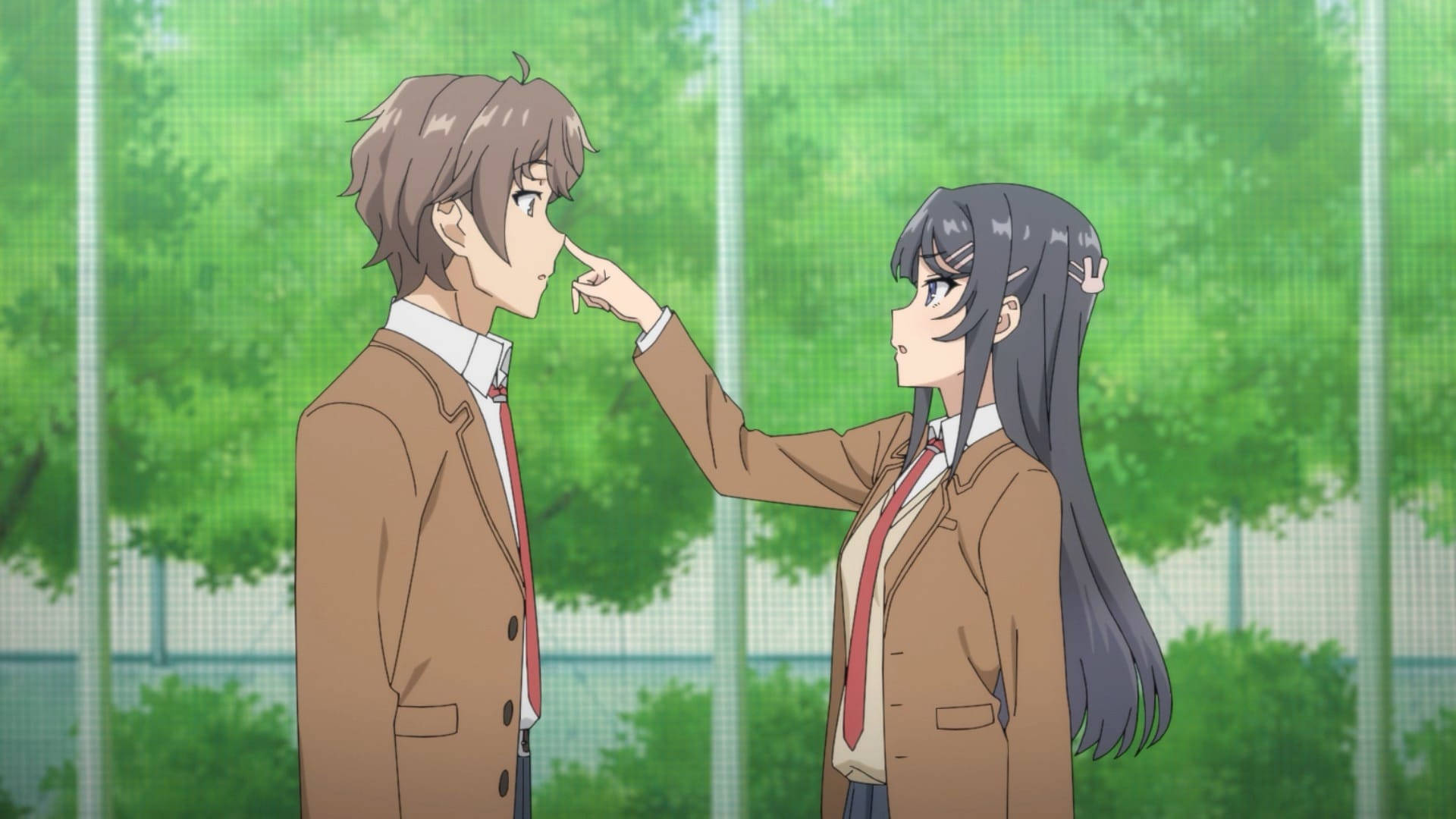 Rascal Does Not Dream Of Bunny Girl Senpai 桌布 壁紙 — 一個穿著校服的女孩輕輕觸摸一個男孩的鼻子，他們在綠色的戶外環境中站得很近。