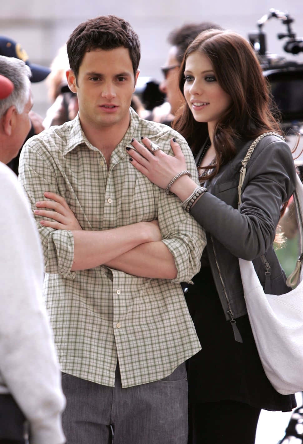 michelle trachtenberg 桌布 壁紙 — 一個穿著格紋襯衫的男人交叉雙臂站著，而一個塗著深色指甲油的女人微笑著輕輕觸碰他的胸膛。