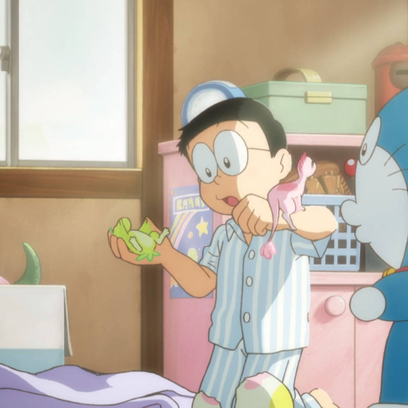 doraemon 4K 桌布 壁紙 — 一個穿著條紋睡衣的小男孩拿著一個綠色青蛙玩具，而一隻藍色機器貓在舒適的臥室旁邊好奇地偷看。