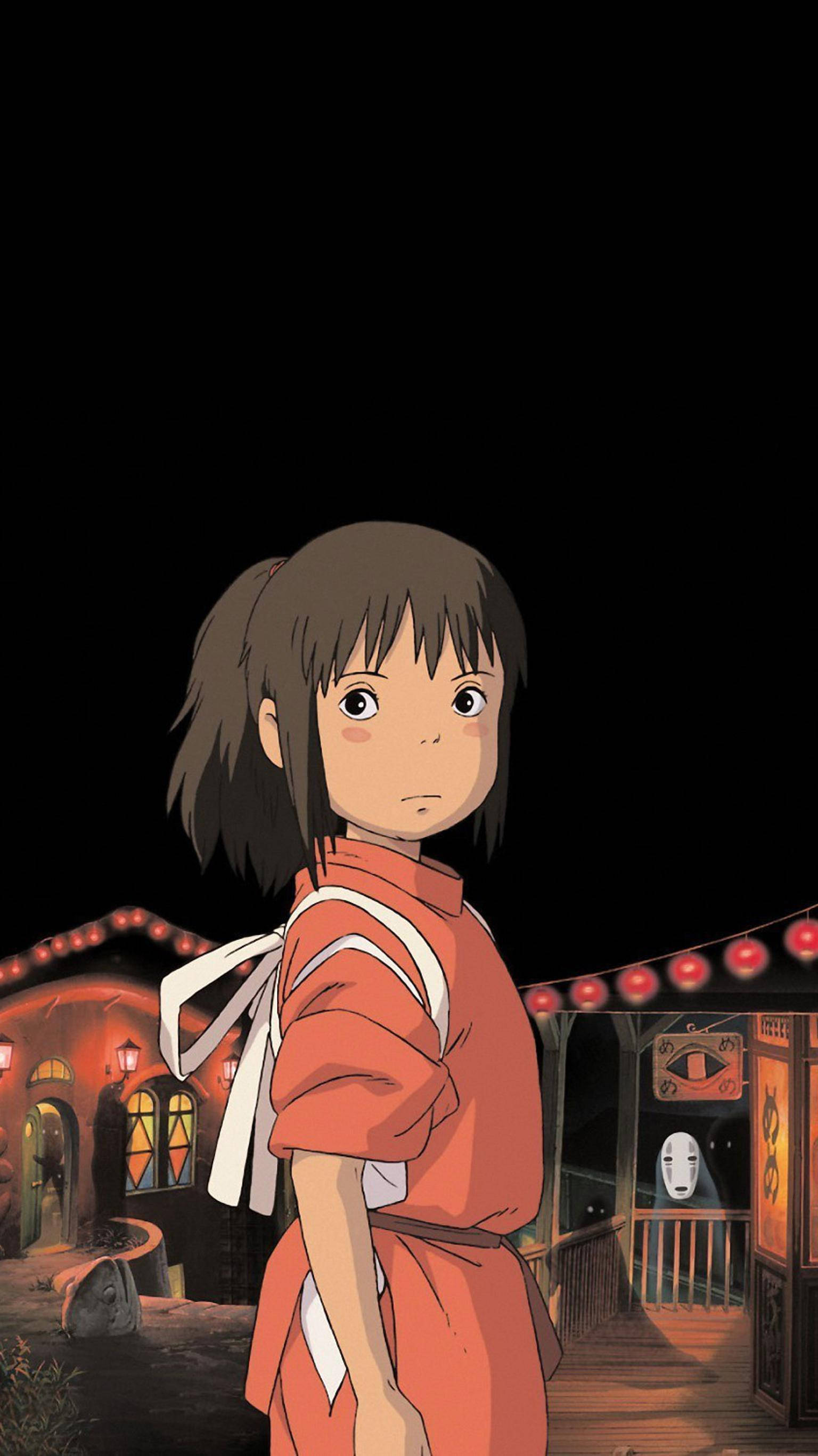 神隱少女 桌布 壁紙 — 一個穿著橙色和服的年輕女孩在夜晚站在一個神秘的村莊，附近有發光的燈籠和一個幽靈般的身影。