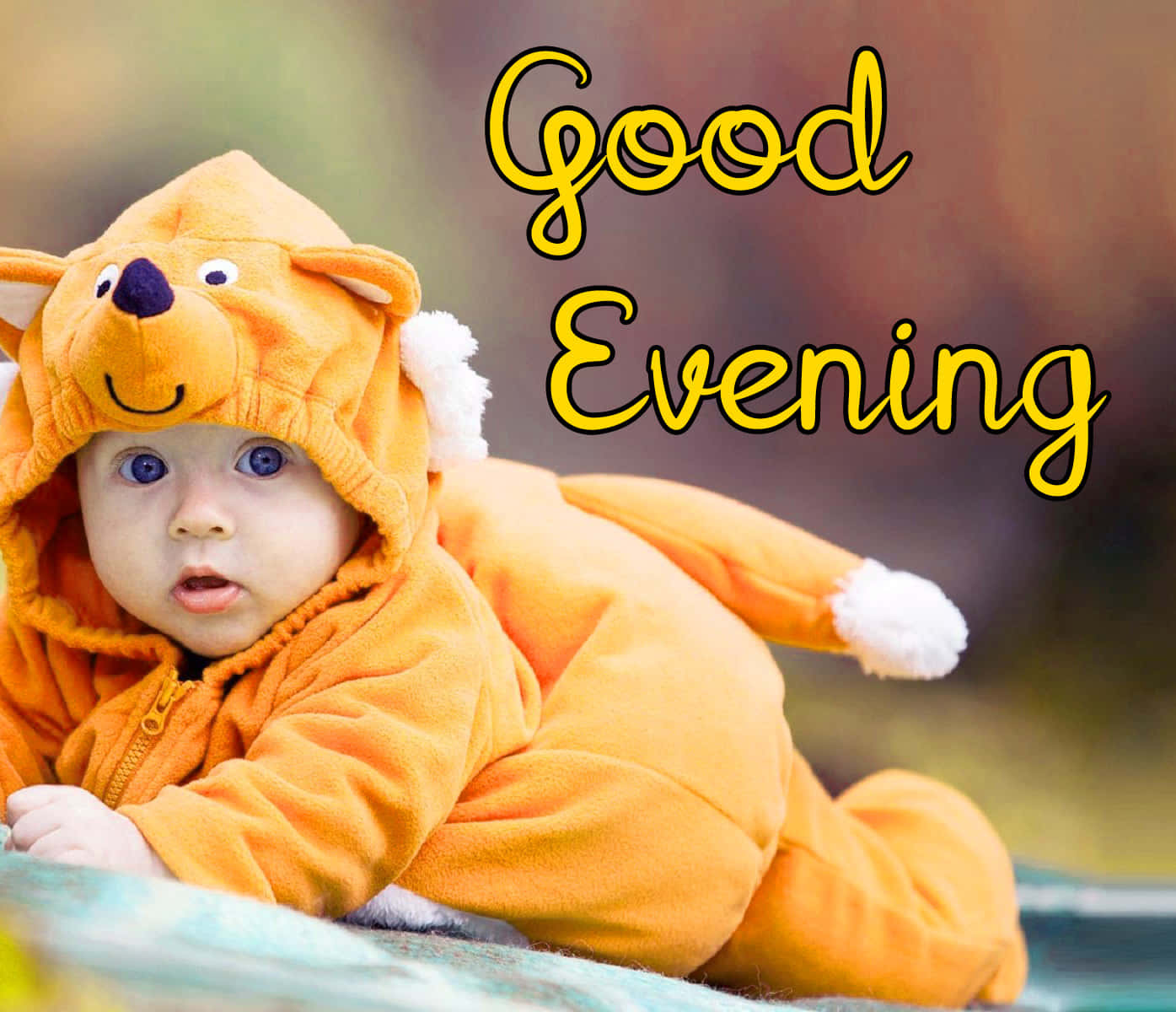 Good Evening 桌布 壁紙 — 一個穿著橙色狐狸服裝的嬰兒躺在毯子上，帶有黃色發光的「晚上好」文字。