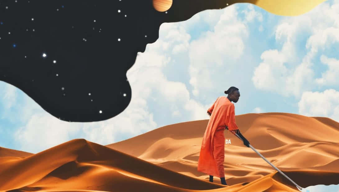 Afrofuturism 桌布 壁紙 — 一個穿著橙色長袍的人物在金色沙丘上行走，天空超現實，混合了星星、雲朵和漂浮的行星。