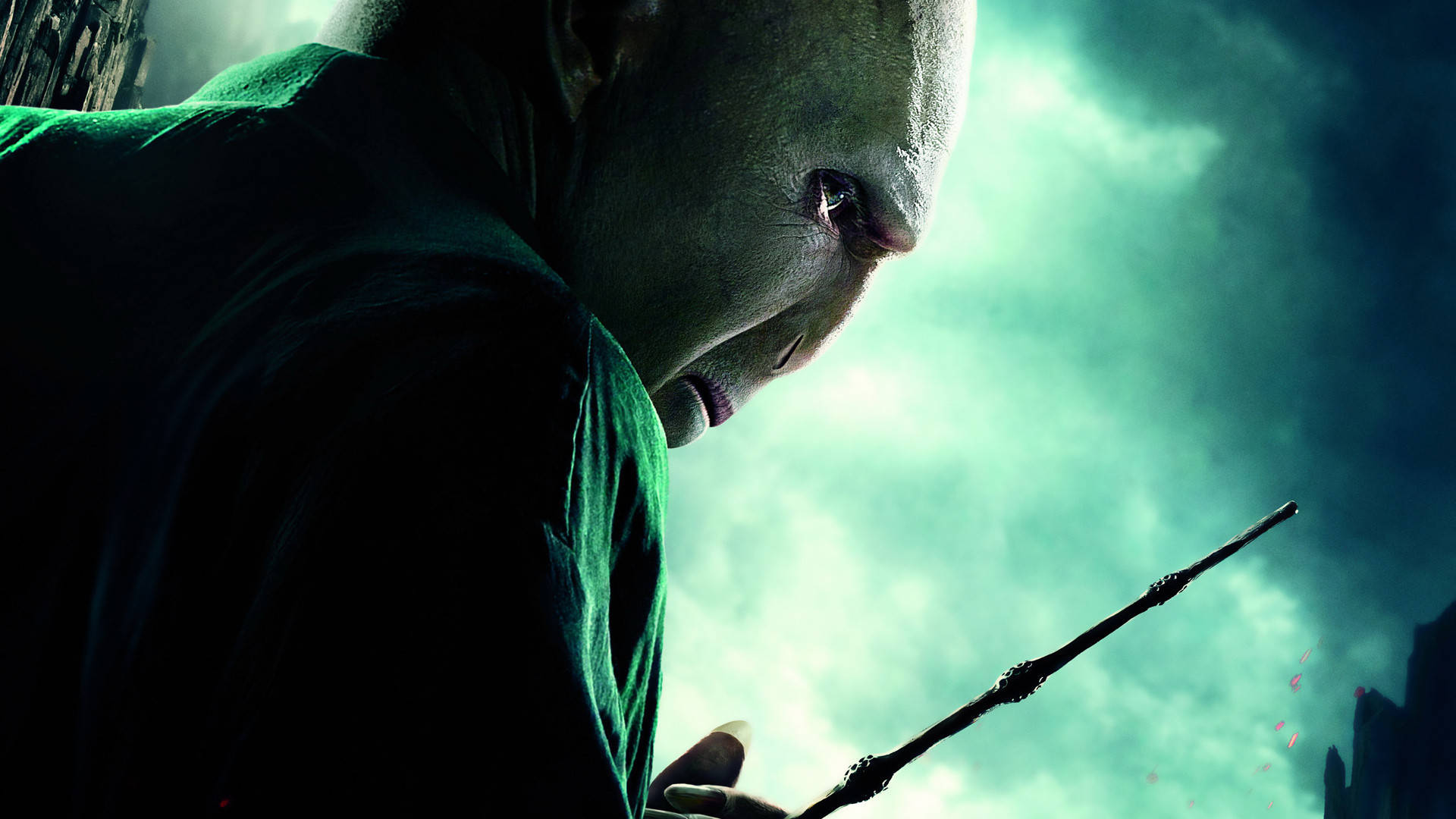 voldemort 桌布 壁紙 — 一個穿著深綠色長袍的光頭威脅人物，在暴風雨的藍綠色天空中揮舞魔杖。