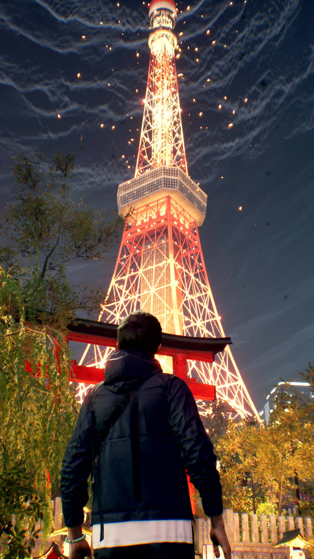 Ghostwire Tokyo 桌布 壁紙 — 一個穿著深色外套的人抬頭仰望燈火輝煌的東京鐵塔，煙火在深藍色的夜空中綻放。