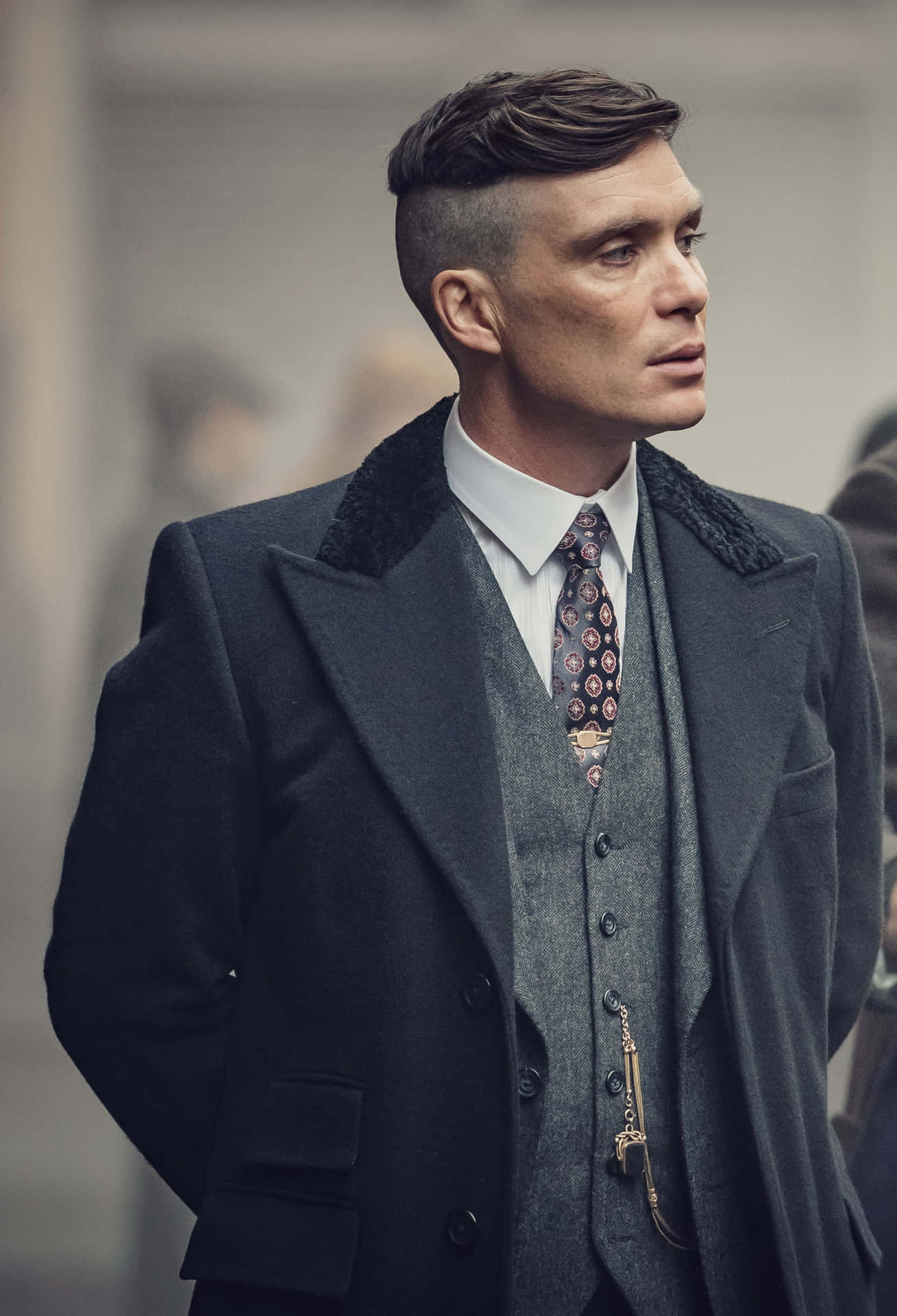 穿著復古西裝和圖案領帶的男人在城市環境中看向鏡頭外 — Peaky Blinders 壁紙