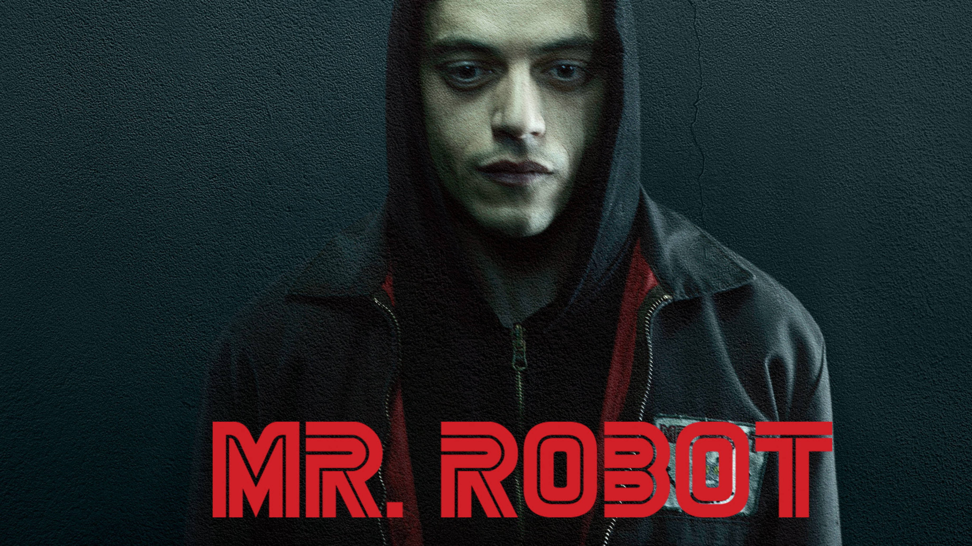 Mr Robot 桌布 壁紙 — 一個穿著深色連帽衫的男人，對著一面有裂縫的牆壁，牆上有粗體紅色「MR. ROBOT」文字，他凝視著。